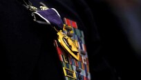 (Former) Chairman of the Joint Chiefs of Staff, Gen. Martin E. Demplsey presents the Purple Heart medal to (then) Tech. Sgt. Richard Chwalik, Dec. 19, 2011 at a town hall meeting during the chairman's visit to Ramstein Air Base, Germany. Chwalik was injured during his deployment to Afghanistan in 2009.