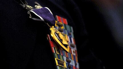 (Former) Chairman of the Joint Chiefs of Staff, Gen. Martin E. Demplsey presents the Purple Heart medal to (then) Tech. Sgt. Richard Chwalik, Dec. 19, 2011 at a town hall meeting during the chairman's visit to Ramstein Air Base, Germany. Chwalik was injured during his deployment to Afghanistan in 2009.