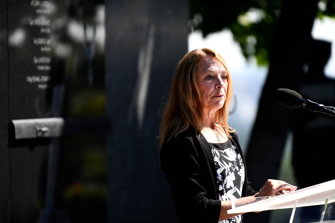 One person standing in front of a memorial wall.