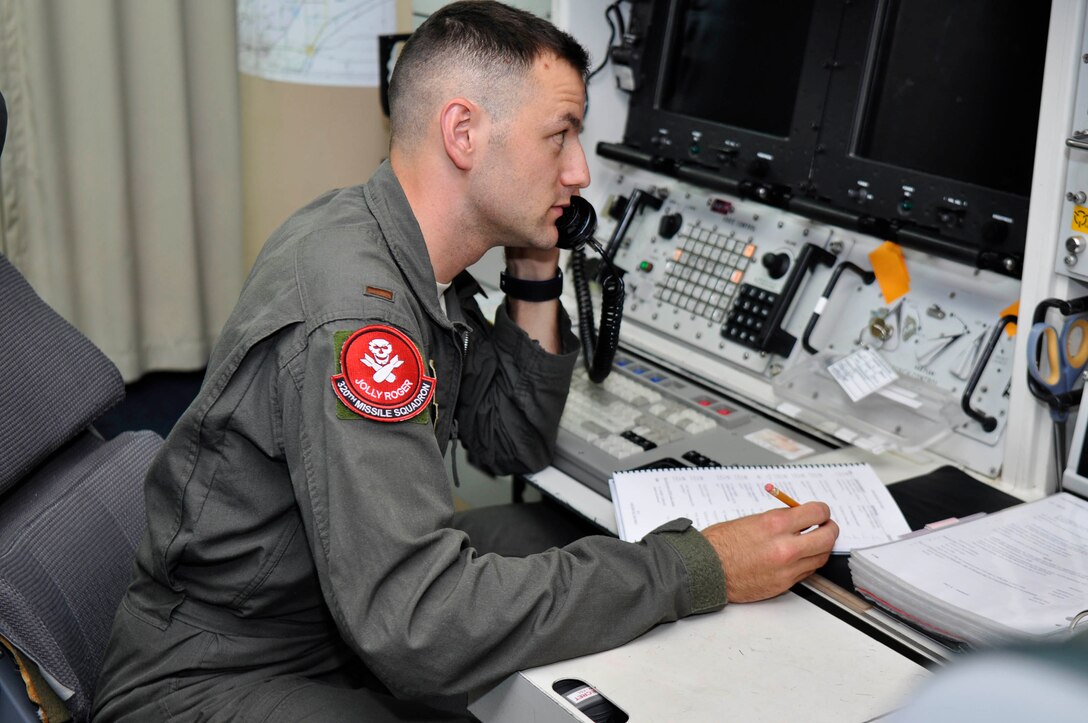 Second Lieutenant Adam Pauley, 320th Missile Squadron deputy combat crew commander, communicates over the phone during a Simulated Electronic Launch-Minuteman test inside a launch control center at a missile alert facility in the 90th Missile Wing missile complex, Aug. 21, 2018. Accomplishing the SELM validates these claims and increases the deterrent capability of the Minuteman III ICBM weapon system. (U.S. Air Force photo by Senior Airman Breanna Carter)