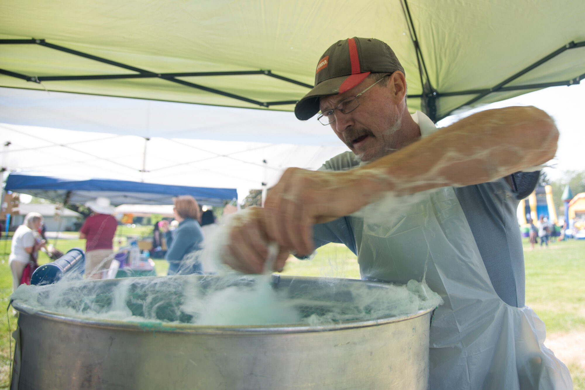 A volunteer spins cotton candy for base children at the 2018 Fairchild Food Truck Festival, Aug. 28, 2018, at Fairchild Air Force Base, Washington. Festival attendees enjoyed free food, rides and could win prizes for participation with visiting vendors. (U.S. Air Force photo/ Senior Airman Ryan Lackey)