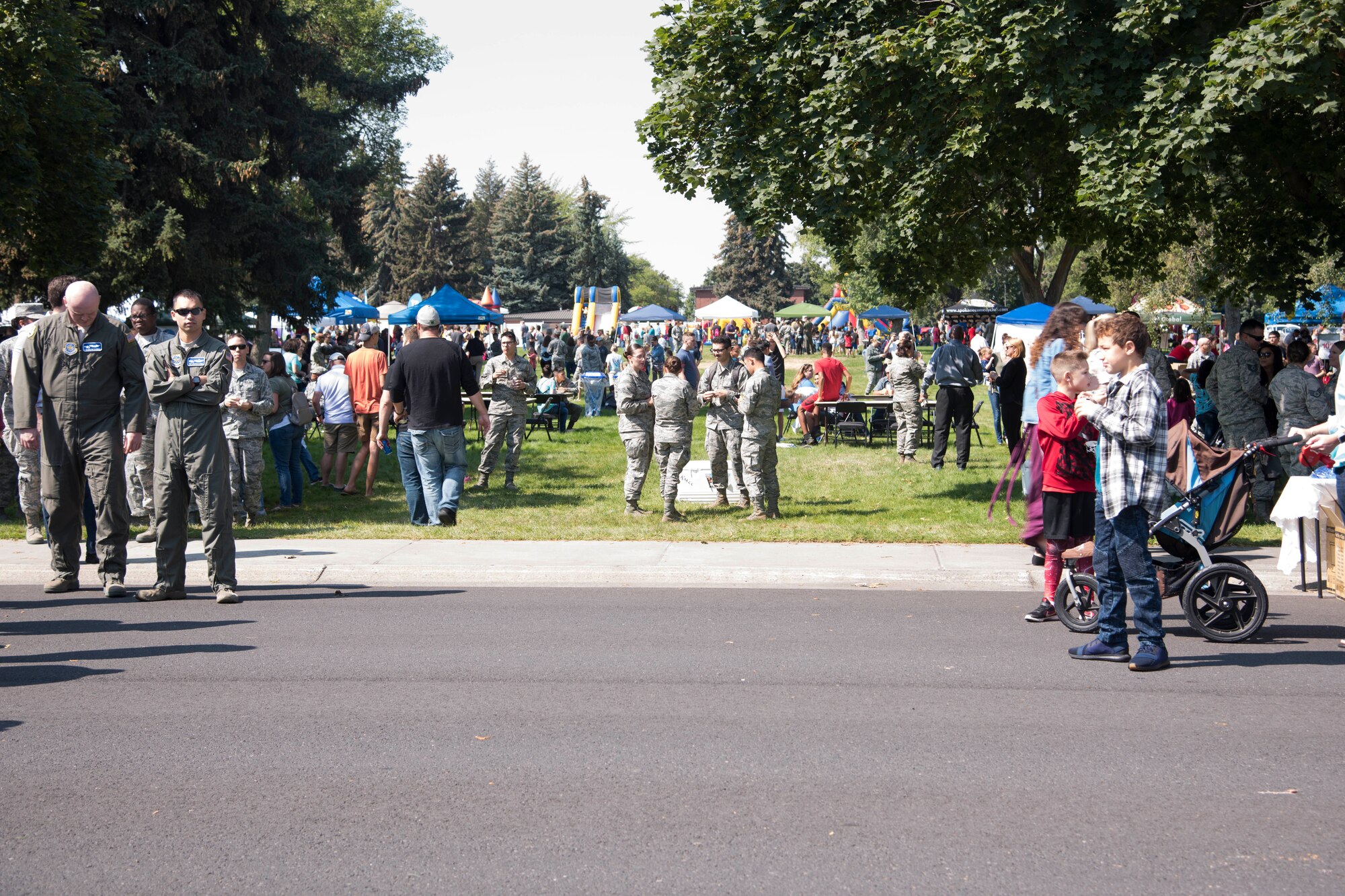 Airmen and their families enjoy the free attractions at the 2018 Fairchild Food Truck Festival, Aug. 28, 2018, at Fairchild Air Force Base, Washington. Hundreds of base residents swarmed the fields near Heritage Park for the festival where they enjoyed free food, rides and could win prizes for participation with visiting vendors. (U.S. Air Force photo/ Senior Airman Ryan Lackey)