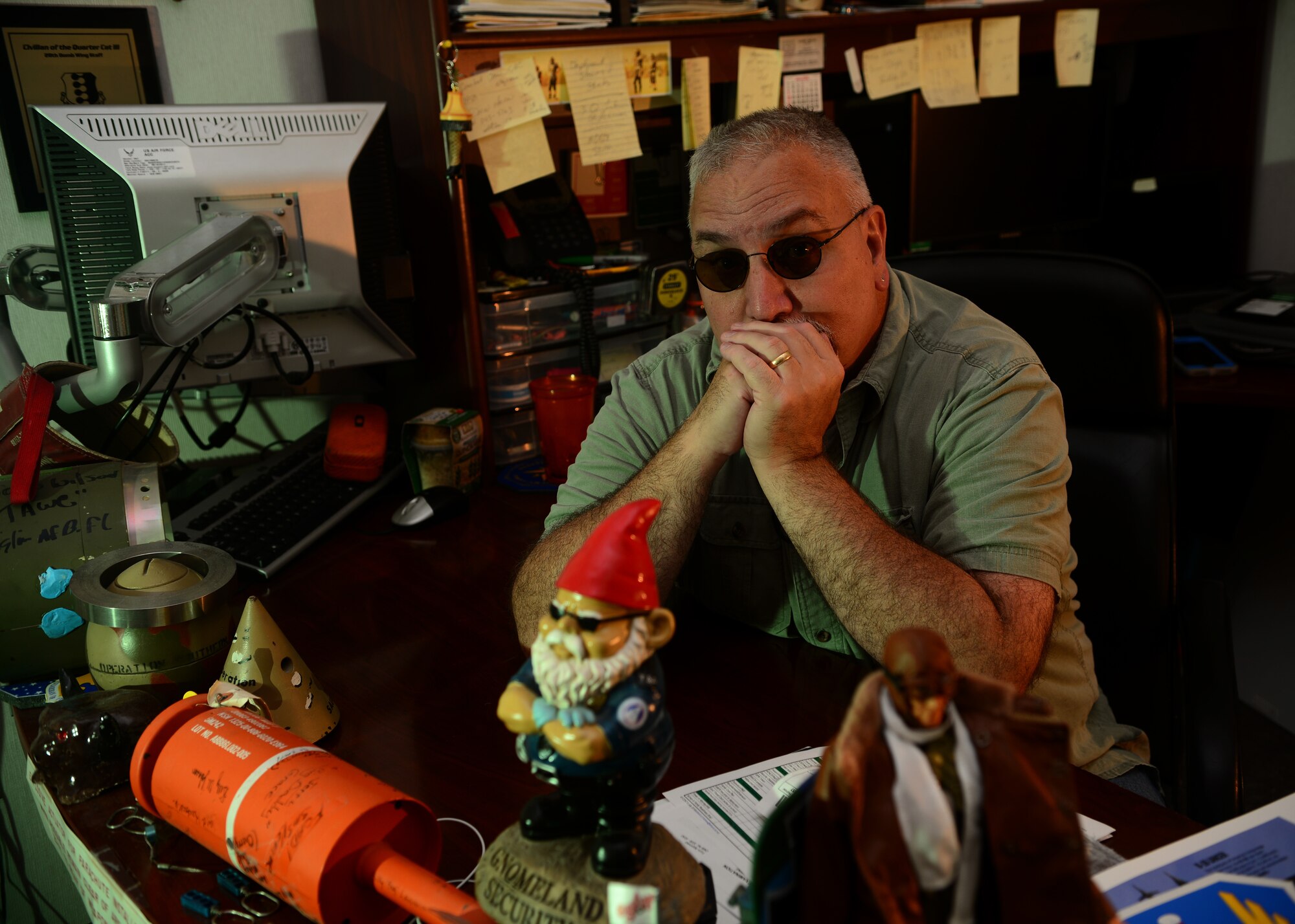 John Moyes, the 28th Bomb Wing historian, poses at his desk inside the 28th BW headquarters on Ellsworth Air Force Base, S.D., Aug. 21, 2018. Moyes was a prior munitions systems specialist and years after separating, became an Air Force historian. (U.S. Air Force photo by Senior Airman Denise Jenson)