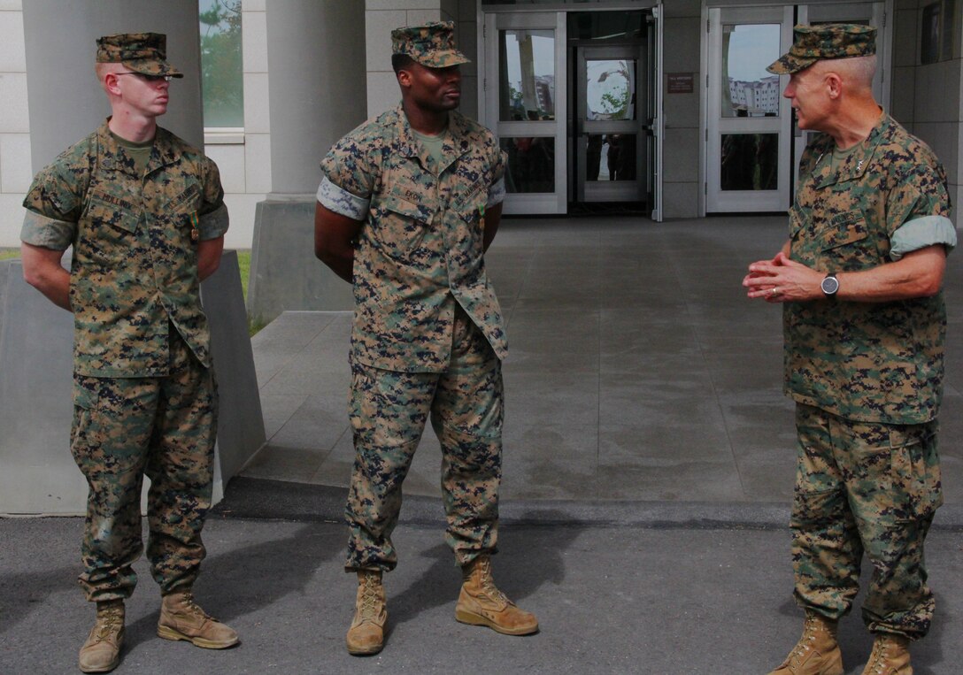 CAMP HUMPHREYS, Republic of Korea – Maj. Gen. Patrick J. Hermesmann (right), U.S. Marine Corps Forces Korea commander, addresses Sgt. Tyler Mullinix (left), G6 helpdesk non-commissioned officer-in-charge, and Sgt. Bassey Ekon (center), G6 net administrator, after awarding them the Navy and Marine Corps Achievement Medal here, Aug. 29. MARFORK recognized Mullinix and Ekon because of their direct contribution to the operational success of the command. (U.S. Marine Corps photo by Capt. John Parry/Released)