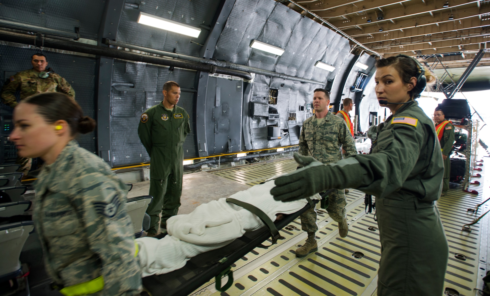 U.S. Air Force Staff Sgt. Rachael Griffin, 94th Aeromedical Evacuation Squadron medical technician, guides litter carriers with simulated patients onto a C-5M Super Galaxy during Exercise Ultimate Caduceus 2018 at Travis Air Force Base, California, Aug. 23, 2018. Ultimate Caduceus 2018 is an annual patient movement exercise designed to test the ability of U.S. Transportation Command to provide medical evacuation. (U.S. Air Force photo by Staff Sgt. Daniel Phelps)