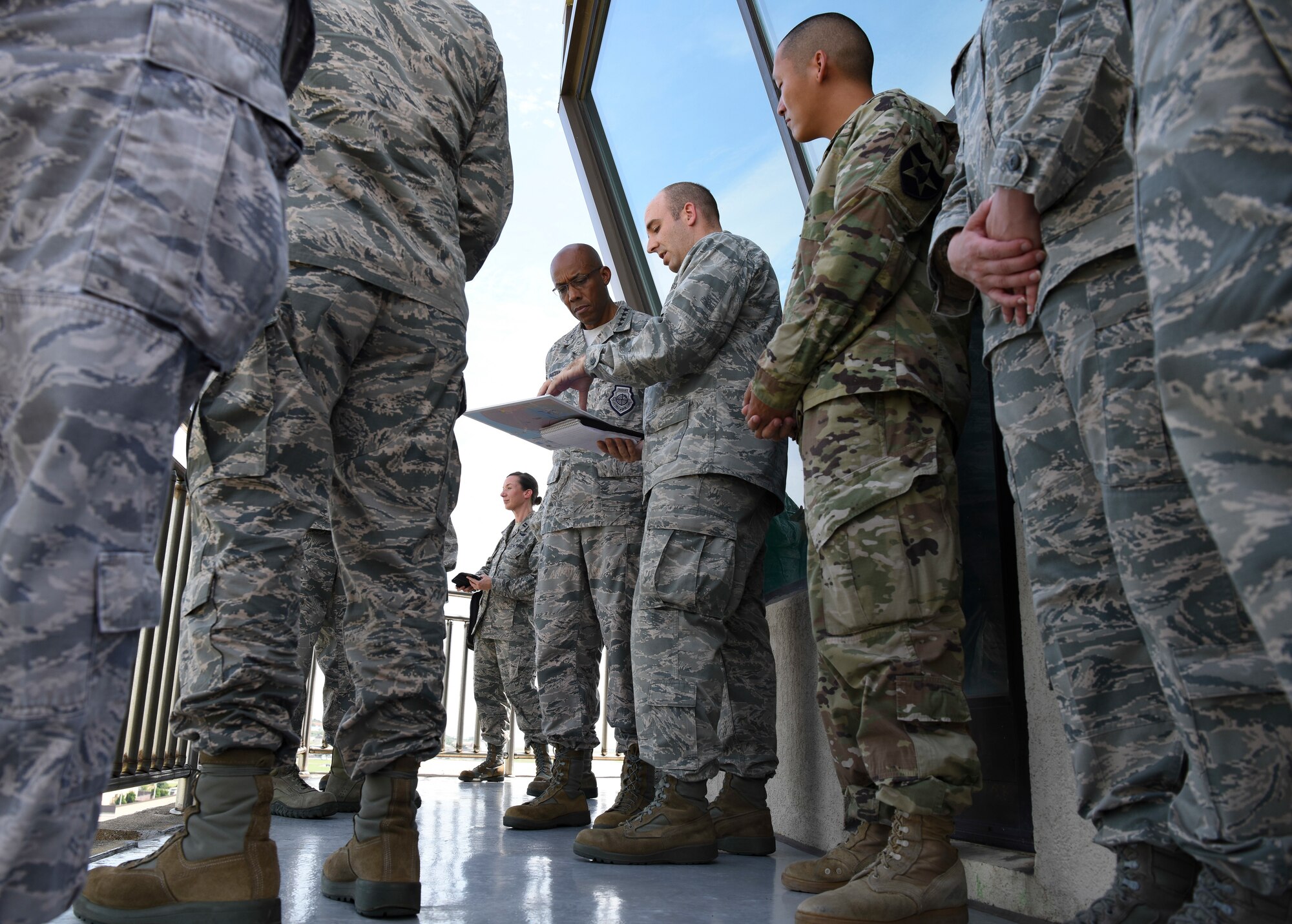 U.S. Air Force Capt. Shaun Hyland-Moore (center), 8th Civil Engineer Squadron engineering flight commander, briefs Gen. CQ Brown, Jr., Pacific Air Forces commander (left), during his immersion tour at Kunsan Air Base, Republic of Korea, Aug. 29, 2018. Airmen from the 8th Fighter Wing briefed Brown on current airfield construction, hazardous material construction, and Department of Defense explosives safety board responsibilities and procedures, while overlooking the installation from the air traffic control tower. (U.S. Air Force photo by Senior Airman Savannah L. Waters)