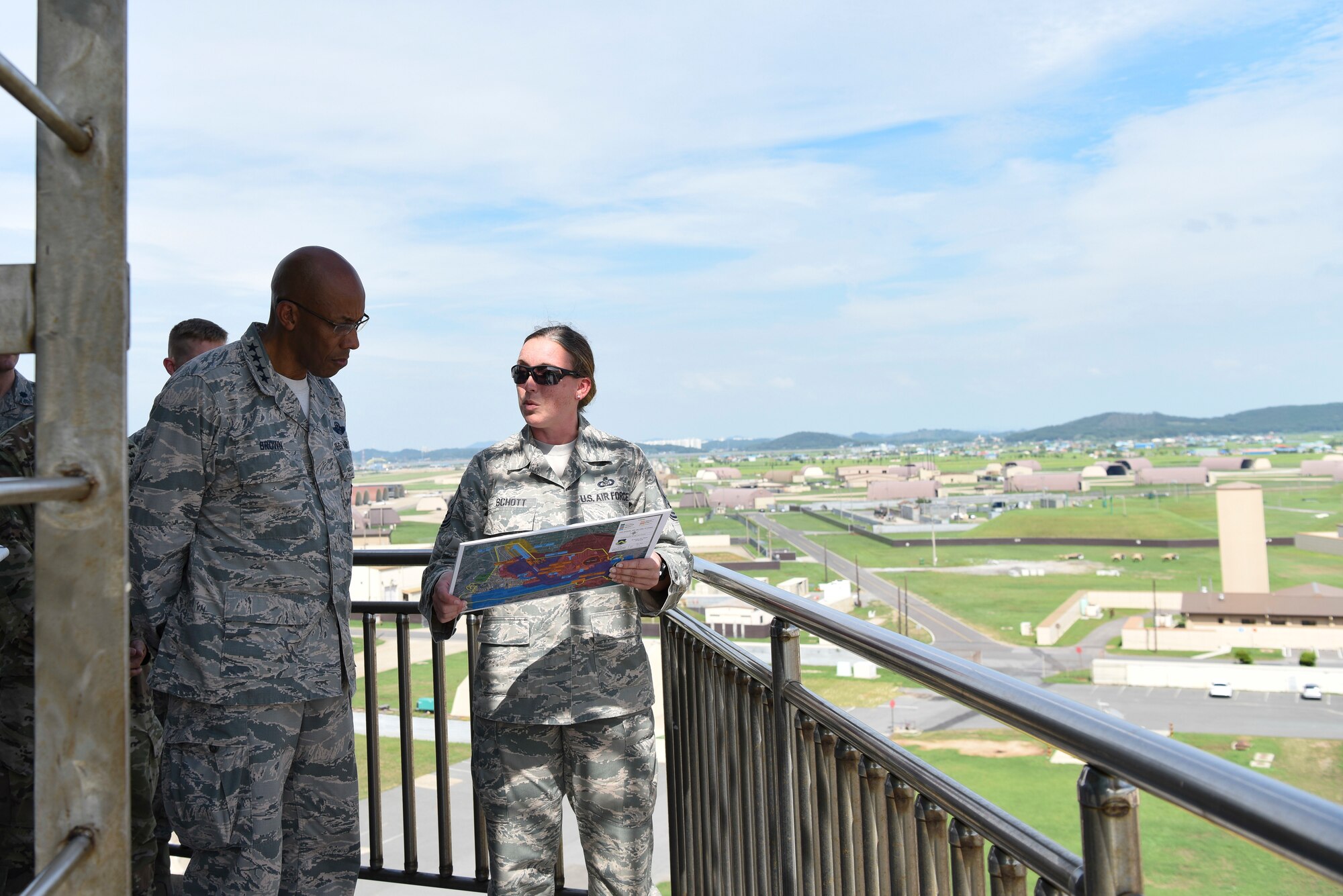 U.S. Air Force Gen. CQ Brown, Jr., Pacific Air Forces commander (left), is briefed atop the air traffic control tower during his immersion tour by Senior Master Sgt. Kristin Schott (right), 8th Operations Support Squadron airfield manager, at Kunsan Air Base, Republic of Korea, Aug. 29, 2018. Airmen from the 8th Fighter Wing briefed Brown on current airfield construction, hazardous material construction, and Department of Defense explosives safety board responsibilities and procedures, while overlooking the installation from the air traffic control tower. (U.S. Air Force photo by Senior Airman Savannah L. Waters)
