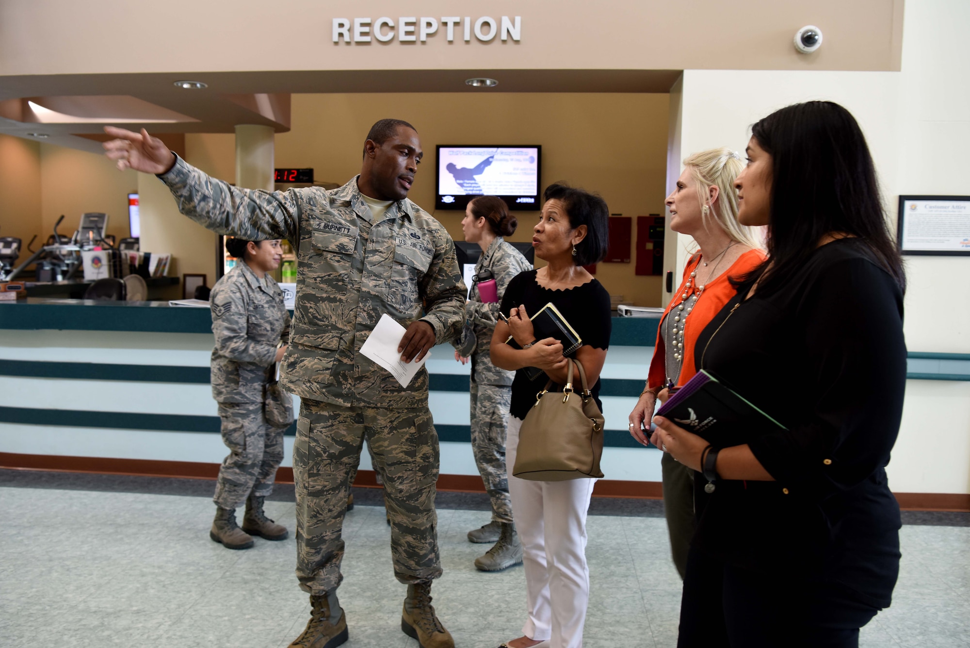 U.S. Air Force Tech. Sgt. Kedist Burnett, 8th Force Support Squadron fitness center noncommissioned officer in charge, briefs Sharene Brown, wife of Gen. CQ Brown, Jr., Pacific Air Forces (PACAF) commander, and Stephanie Johnson, spouse of Chief Master Sgt. Anthony Johnson, PACAF command chief, on amenities offered at the fitness center at Kunsan Air Base, Republic of Korea, Aug. 29, 2018.  Their visit at Kunsan was part of a four-day immersion in the Republic of Korea, offering the opportunity to meet with key U.S. and ROK leadership and Airmen. (U.S. Air Force photo by Staff Sgt. Jasmonet D. Jackson)