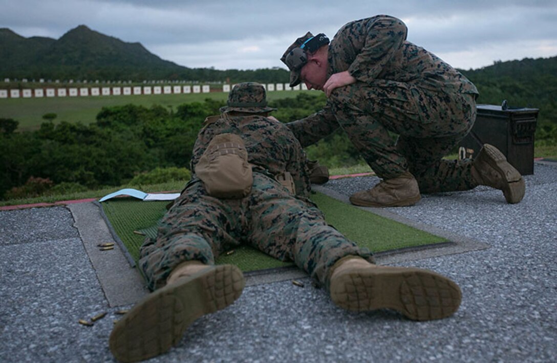 Lance Cpl. Timothy Larrigan, a range coach from Headquarters Battalion, 3rd Marine Division, gives advice to a fellow Marine during annual rifle range qualification on Camp Hansen, Okinawa, Japan, August 20, 2018. Marines qualify annually with the M16A4 service rifle to maintain combat effectiveness. Larrigan is a native of Fenton, Missouri. (U.S. Marine Corps photo by. Lance Cpl Christine Phelps)