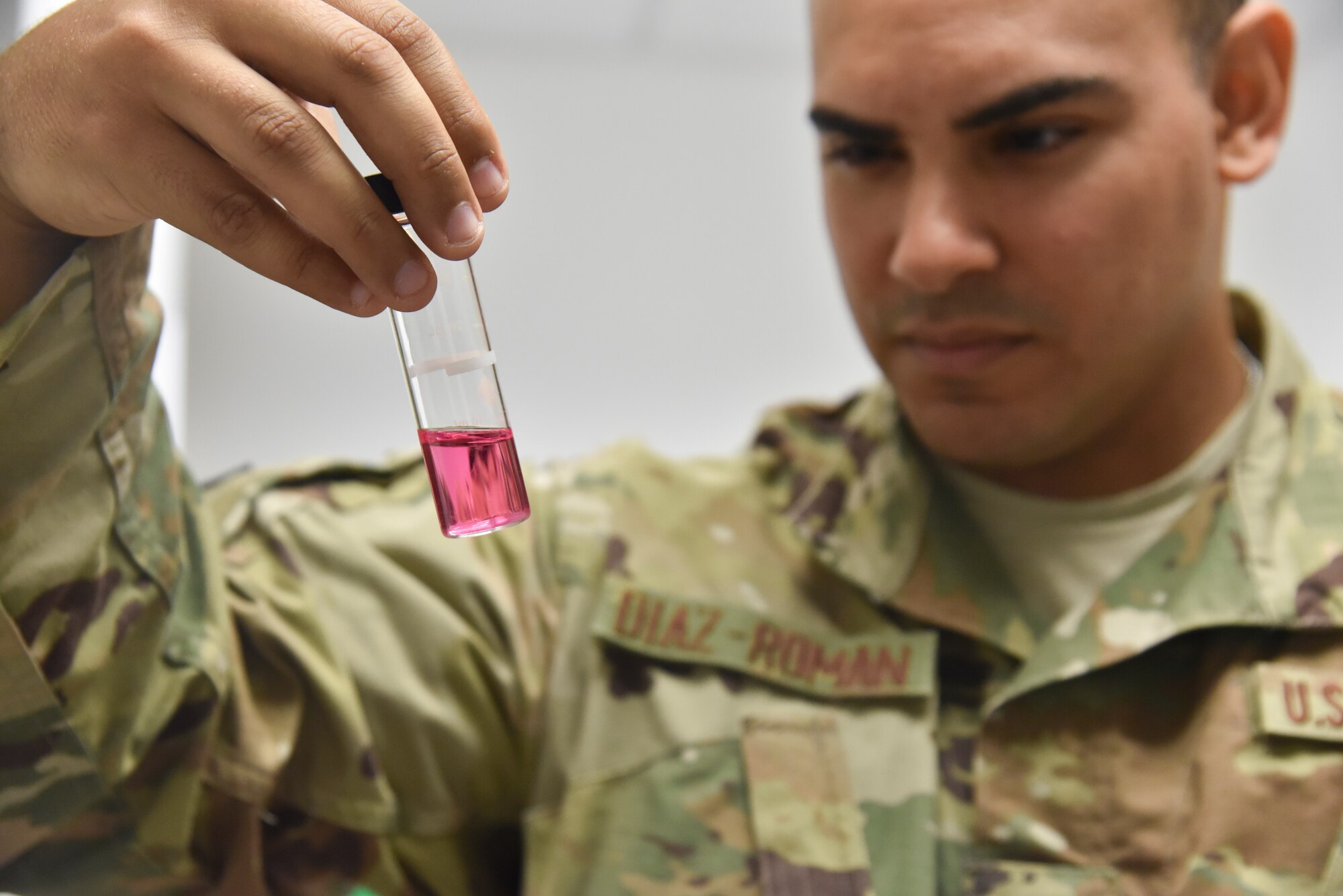 Senior Airman Mizraim Diaz-Roman, bioenvironmental water program manager, 379th Expeditionary Medical Operations Squadron, examines a water sample at Al Udeid Air Base, Qatar, August 22, 2018. Both bottled water and municipal water from the tap on base are tested weekly and monthly for bacteria and acidity. (U.S. Air Force photo by Staff. Sgt. Enjoli Saunders)