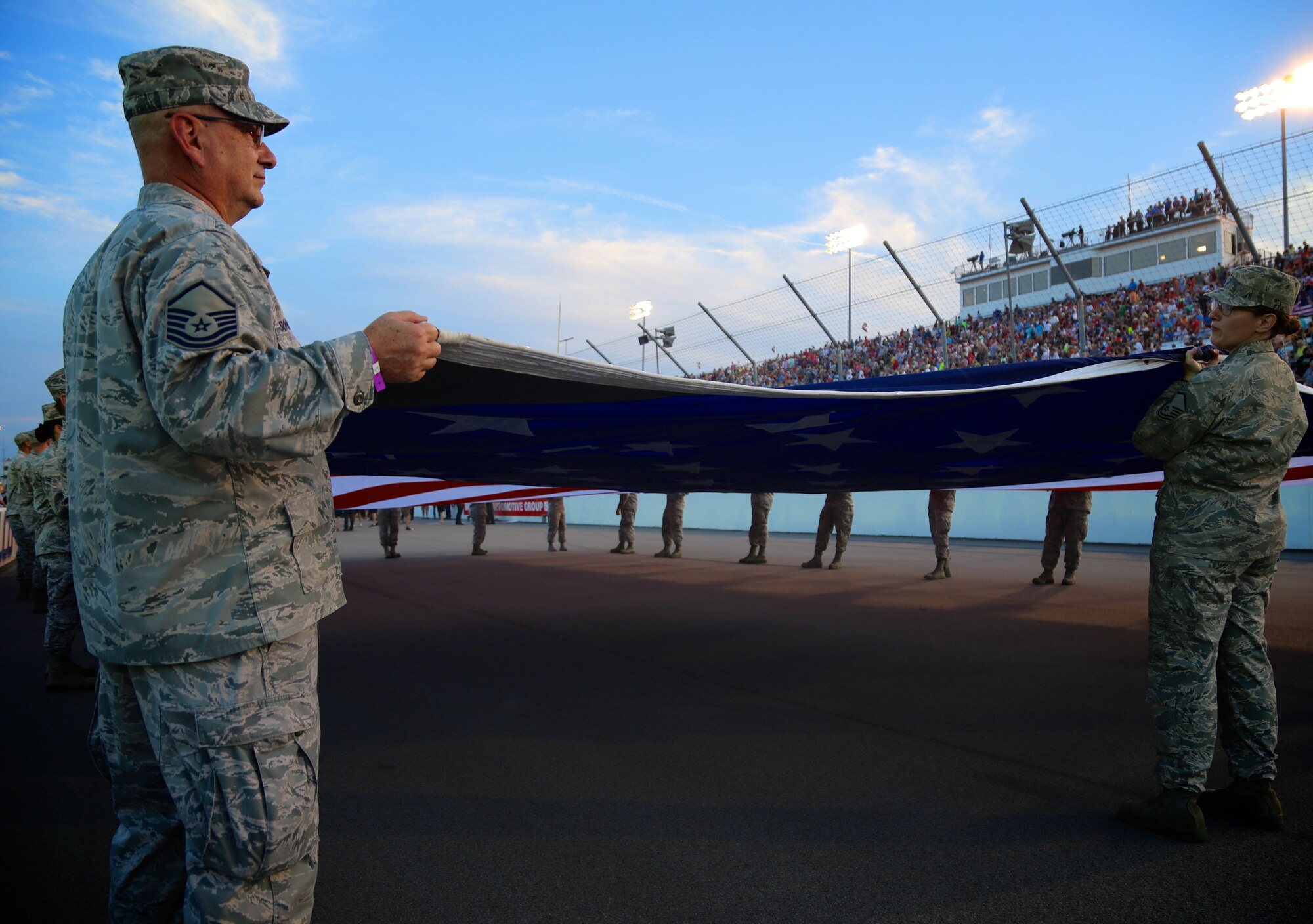 Master Sgt. Gerald Sonnenberg and Master Sgt. Karen Ridge prepare the American flag for the national anthem in front of a packed Indycar crowd August 25, 2018.  As part of the event, 932nd Airlift Wing Maintenance Group commander, Col. Sharon Johnson, was recognized on stage with the Indy drivers at the Bommarito Automotive Group 500.  The race was held at Gateway Motorsports Park, Madison, Illinois. Johnson was an honored VIP to help kick off the 2nd annual IndyCar race which was won by Will Power,  won the 248-lap race around the four-turn, 1.25-mile Gateway Motorsports Park paved track in Madison, Illinois, in his #12 Chevrolet by 1.3 seconds over second place finisher Alexander Rossi.  The 932nd Airlift Wing was represented by maintenance, medical, public affairs staff and operations personnel.  (U.S. Air Force photo by Lt. Col. Stan Paregien)
