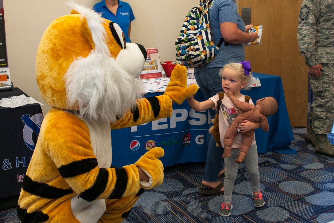 A participant high-fives the Flying Tiger during the Food Show at the Georgia Pines Dining Facility, Aug. 29, 2018, at Moody Air Force Base, Ga. The Food show is an innovative way to give Airmen an opportunity to try various healthy foods and give feedback. The event allowed the dining facility to focus on incorporating items that meet special dietary needs such as vegan, gluten-free, smoothie bar items and healthy snacks. (U.S. Air Force photo by Airman Taryn Butler)