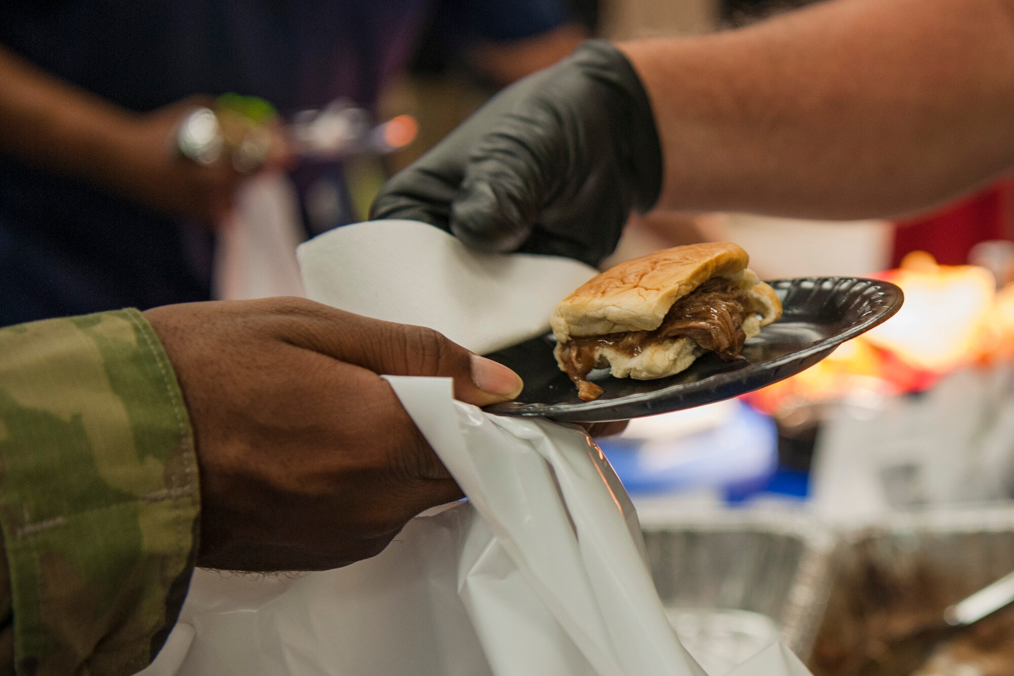 A vendor hands a sandwich to an Airman during the Food Show at the Georgia Pines Dining Facility, Aug. 29, 2018, at Moody Air Force Base, Ga. The Food show is an innovative way to give Airmen an opportunity to try various healthy foods and give feedback. The event allowed the dining facility to focus on incorporating items that meet special dietary needs such as vegan, gluten-free, smoothie bar items and healthy snacks. (U.S. Air Force photo by Airman Taryn Butler)