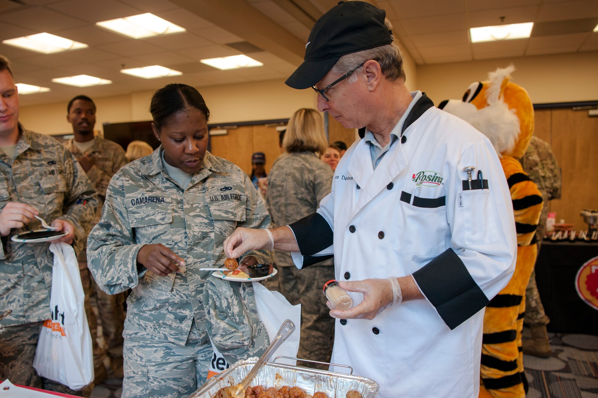 A vendor fills an Airman’s plate during the Food Show at the Georgia Pines Dining Facility, Aug. 29, 2018, at Moody Air Force Base, Ga. The Food show is an innovative way to give Airmen an opportunity to try various healthy foods and give feedback. The event allowed the dining facility to focus on incorporating items that meet special dietary needs such as vegan, gluten-free, smoothie bar items and healthy snacks. (U.S. Air Force photo by Airman Taryn Butler)
