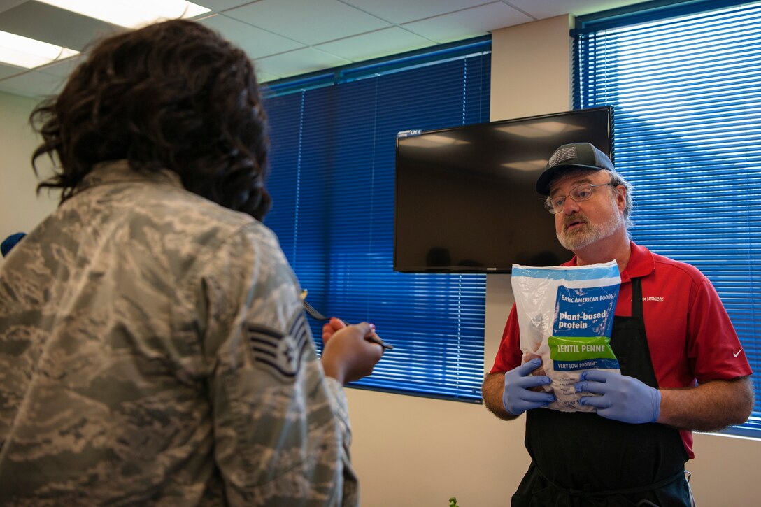 A vendor talks with Staff Sgt. Domineeq Lemon, 23d Logistics Readiness Squadron sortie production, during the Food Show at the Georgia Pines Dining Facility, Aug. 29, 2018, at Moody Air Force Base, Ga. The Food show is an innovative way to give Airmen an opportunity to try various healthy foods and give feedback. The event allowed the dining facility to focus on incorporating items that meet special dietary needs such as vegan, gluten-free, smoothie bar items and healthy snacks. (U.S. Air Force photo by Airman Taryn Butler)