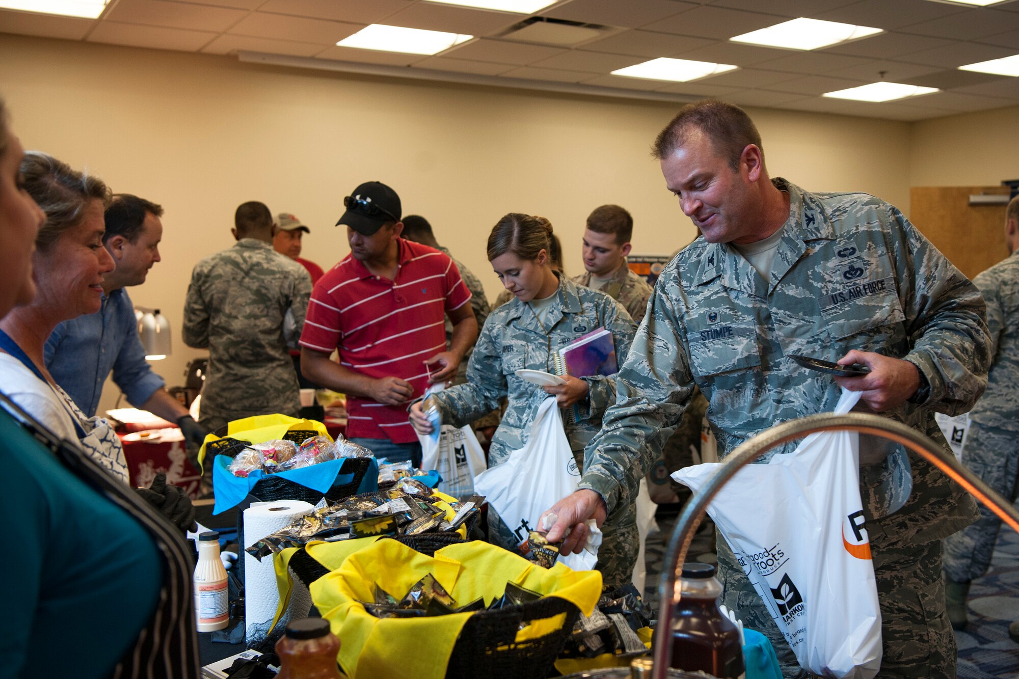 Col. Brian Stumpe, far right, 23d Mission Support Group commander, picks up sunflower seeds during the Food Show at the Georgia Pines Dining Facility, Aug. 29, 2018, at Moody Air Force Base, Ga. The Food show is an innovative way to give Airmen an opportunity to try various healthy foods and give feedback. The event allowed the dining facility to focus on incorporating items that meet special dietary needs such as vegan, gluten-free, smoothie bar items and healthy snacks. (U.S. Air Force photo by Airman Taryn Butler)