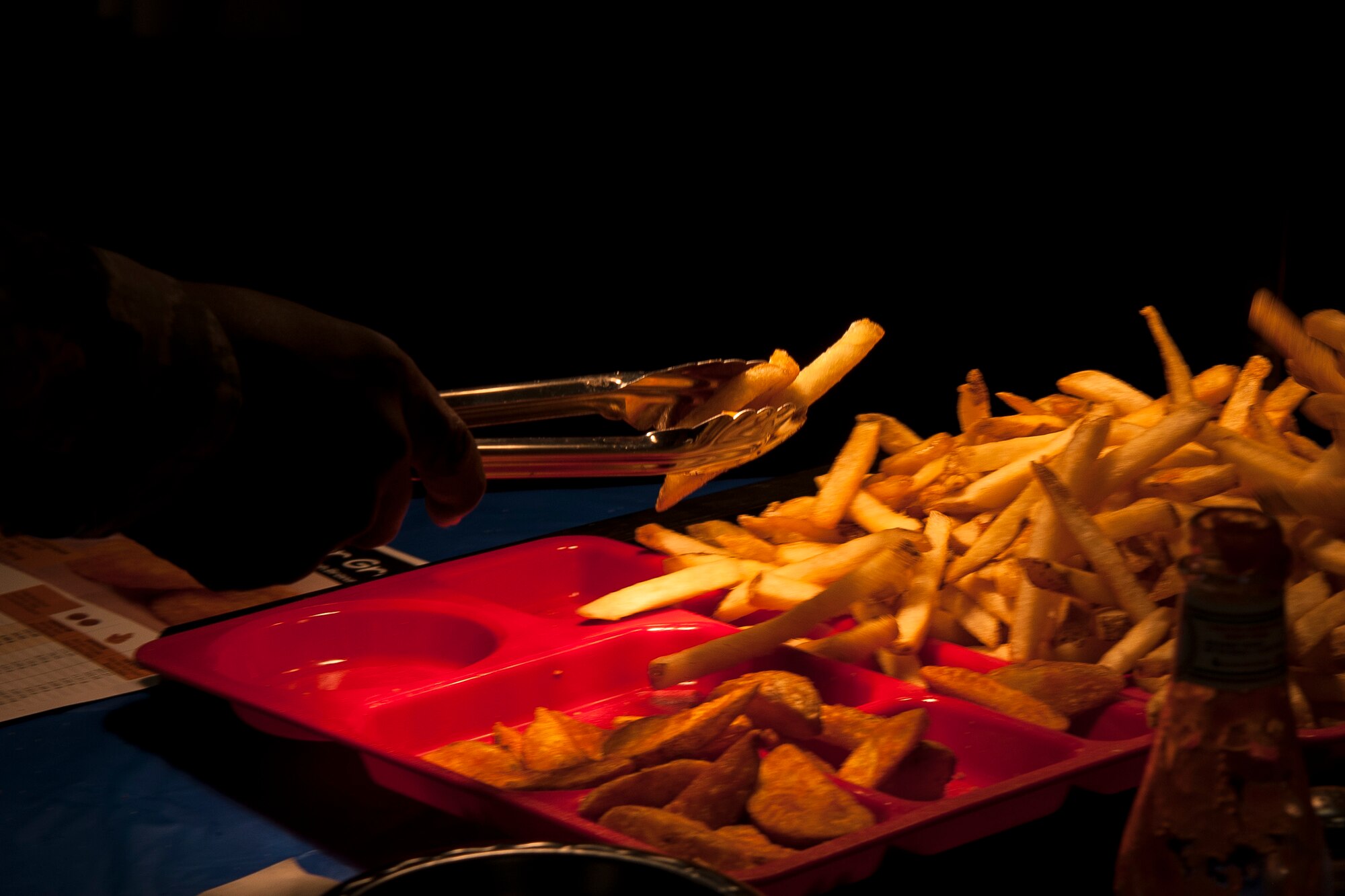 An Airman picks up fries during the Food Show at the Georgia Pines Dining Facility, Aug. 29, 2018, at Moody Air Force Base, Ga. The Food show is an innovative way to give Airmen an opportunity to try various healthy foods and give feedback. The event allowed the dining facility to focus on incorporating items that meet special dietary needs such as vegan, gluten-free, smoothie bar items and healthy snacks. (U.S. Air Force photo by Airman Taryn Butler)