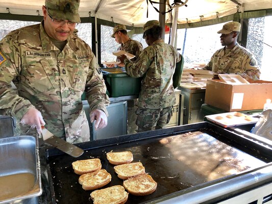 Army Master Sgt. Lewmas Laurinaitis, a culinary specialist with the 16th Sustainment Brigade, cooks French toast in a mobile kitchen with subsistence items provided by DLA during Saber Strike 2018.