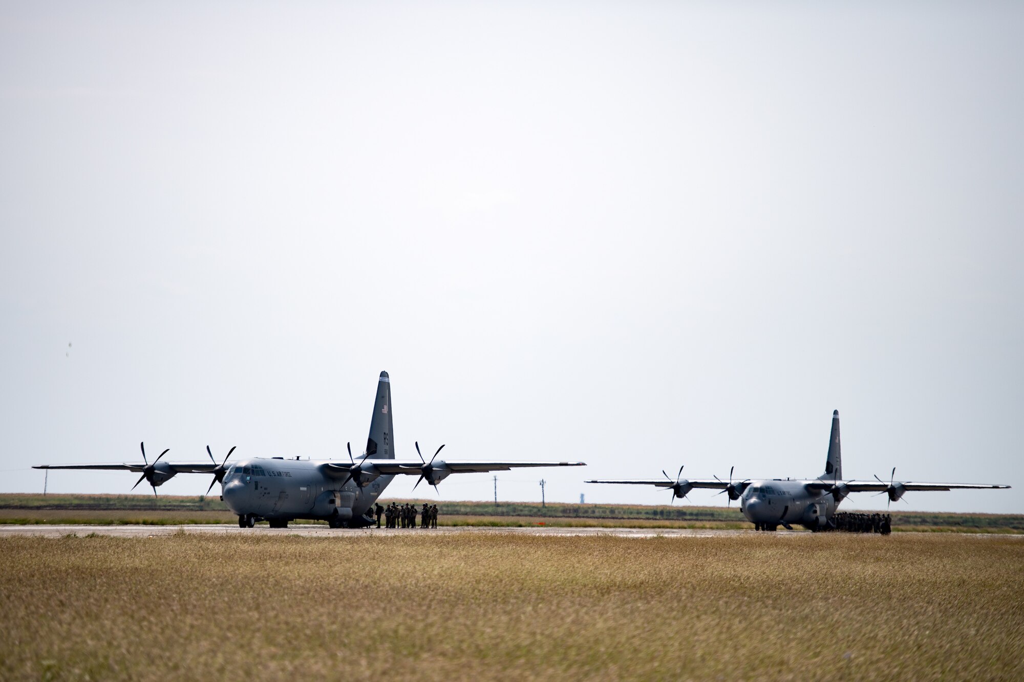 Romanian air force paratroopers board U.S. Air Force C-130J Super Hercules aircraft assigned to the 37th Airlift Squadron, Ramstein Air Base, Germany, on Boboc Air Base, Romania, Aug. 23, 2018. The aircraft then flew over the installation as the paratroopers performed static-line drops as part of exercise Carpathian Summer 2018. (U.S. Air Force photo by Senior Airman Devin Boyer)