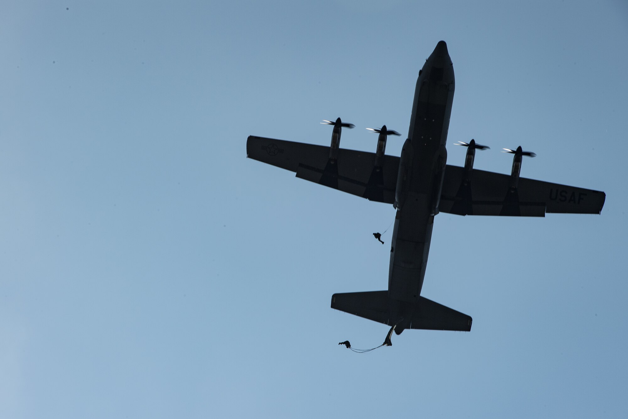 Romanian air force paratroopers jump out of a U.S. Air Force C-130J Super Hercules aircraft assigned to the 37th Airlift Squadron, Ramstein Air Base, Germany, over Boboc Air Base, Romania, Aug. 23, 2018. The airdrops were part of exercise Carpathian Summer 2018, a bilateral training exercise designed to enhance interoperability and readiness of forces by conducting combined air operations with the Romanian air force. (U.S. Air Force photo by Senior Airman Devin Boyer)
