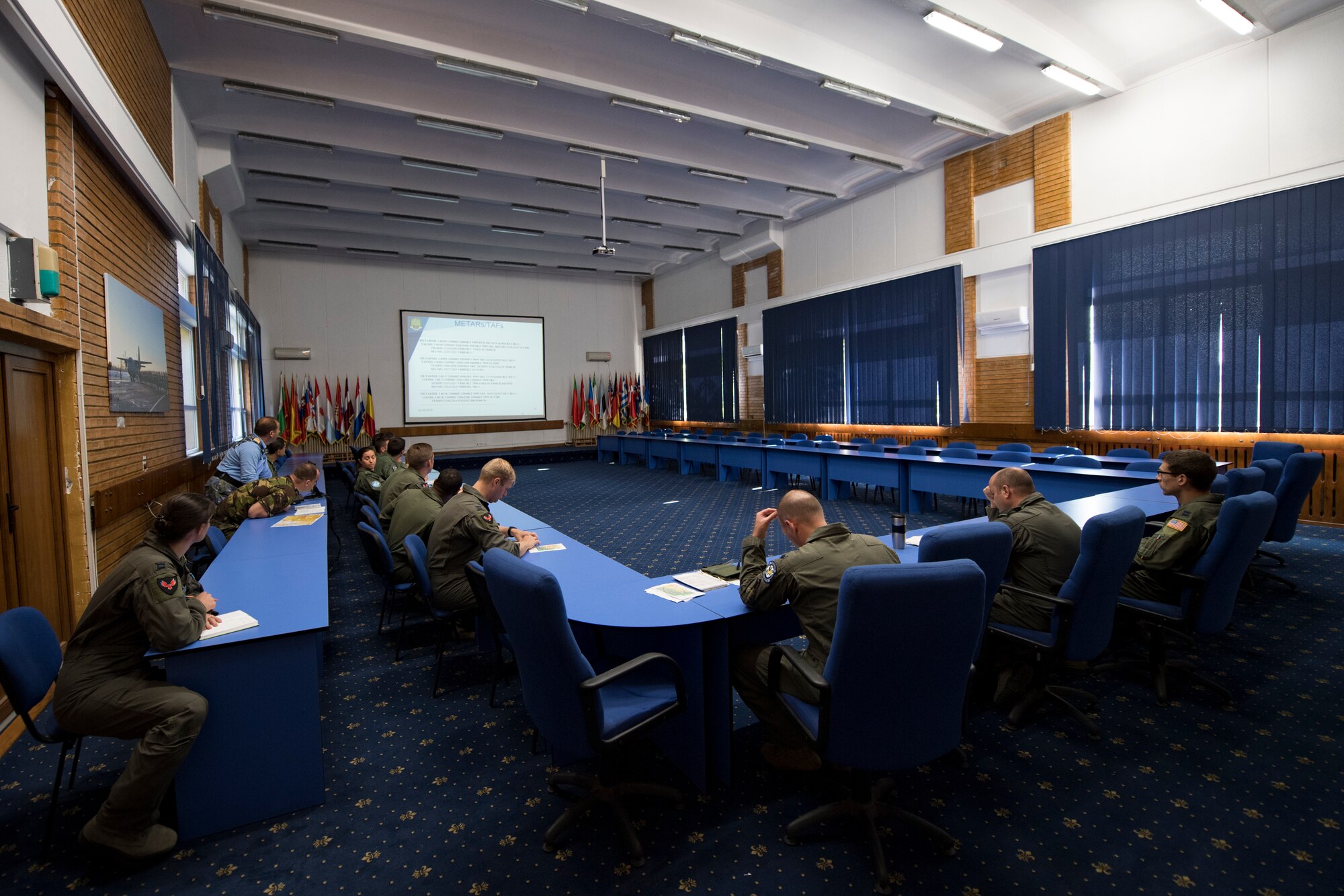 U.S. Air Force and Romanian air force personnel brief each other on daily objectives for exercise Carpathian Summer 2018 on Otopeni Air Base, Romania, Aug. 22, 2018. Carpathian Summer is a bilateral training exercise designed to enhance interoperability and readiness of forces by conducting combined air operations with the Romanian air force. (U.S. Air Force photo by Senior Airman Devin Boyer)