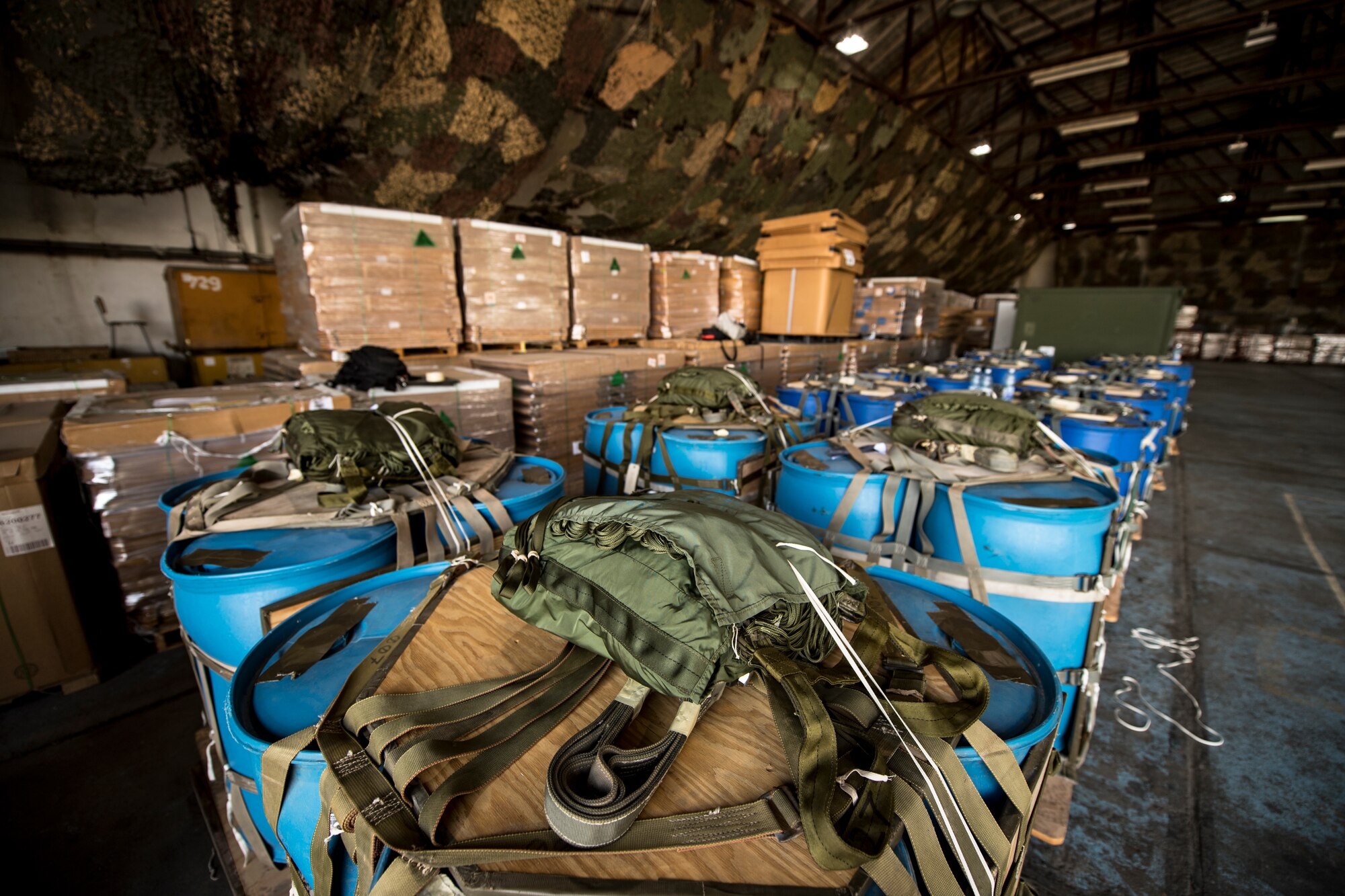 Multiple container delivery system bundles sit in a hangar at Otopeni Air Base, Romania, before U.S. Air Force and Romanian air force personnel load them onto C-130J Super Hercules aircraft assigned to the 37th Airlift Squadron, Ramstein Air Base, Germany, Aug. 22, 2018. Pilots and loadmasters from the 37th AS flew over designated drop zones to deliver the bundles as part of exercise Carpathian Summer 2018. (U.S. Air Force photo by Senior Airman Devin Boyer)
