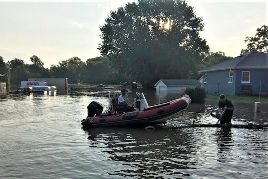 Firefighters launch a boat in floodwaters.