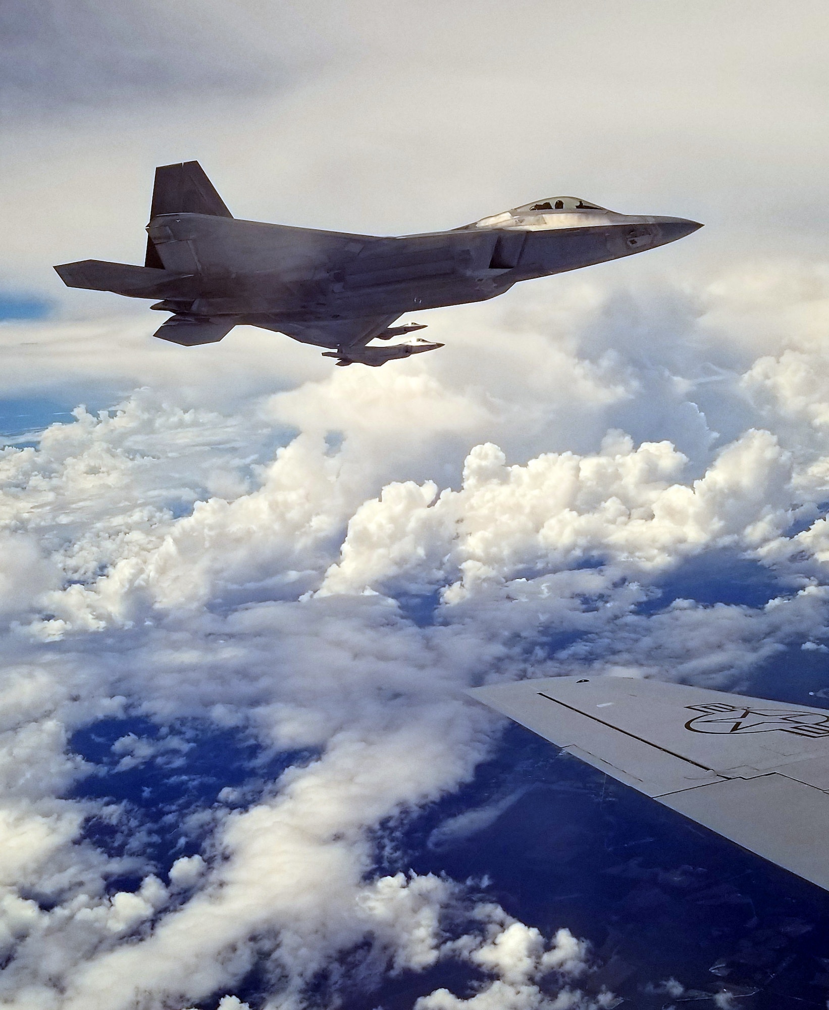 U.S. Air Force F-22 Raptors from the 325th Fighter Wing, Tyndall Air Force Base, Florida, fly alongside a KC-135 Stratotanker from MacDill Air Force Base during a Civic Leader Tour’s refueling demonstration over the Gulf of Mexico, May 21, 2018. F-22 pilots have to complete the F-22 Raptor Basic Course at Tyndall to be qualified to fly the fifth generation aircraft. The B-Course entails emergency procedures, instrument tasks, and day and night air-to-air refueling. The students are also educated on air-to-air employment, air-to-ground employment, basic low altitude employment and night-vision goggle and night employment. (U.S. Air Force photo by Airman 1st Class Isaiah J. Soliz)