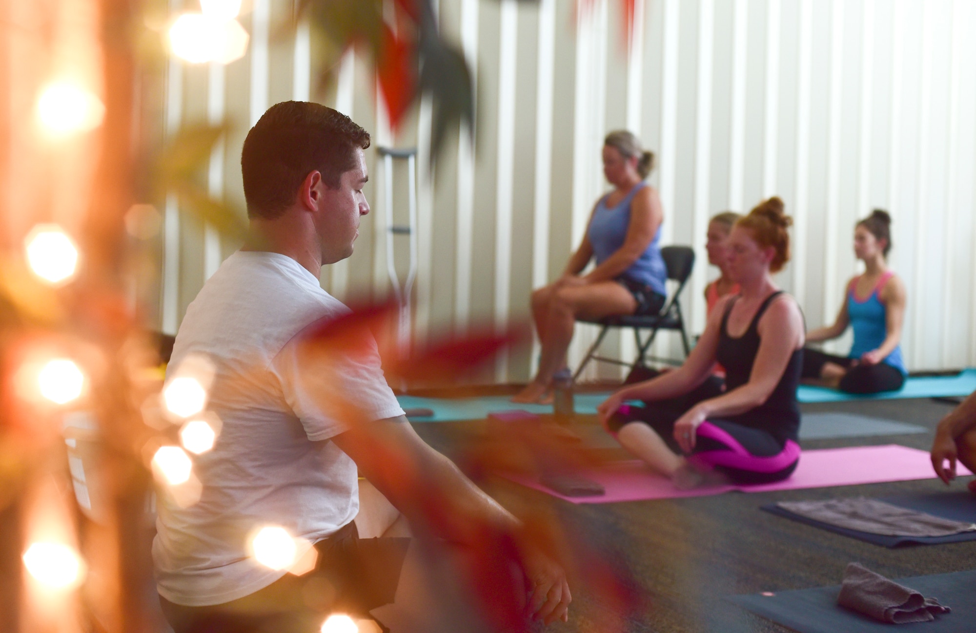 U.S. Air Force Master Sgt. Ramiro Villalobos, Paul W. Airey Noncommissioned Officer Academy instructor, meditates at the beginning of a Tyndall Pacesetters yoga class at the Balfour Beatty Community Center on Tyndall Air Force Base, Florida, Aug. 22, 2018. Regular yoga sessions can produce a number of benefits like lessening chronic pain, such as lower back pain, arthritis, headaches and carpal tunnel syndrome. (U.S. Air Force photo by Senior Airman Cody R. Miller)