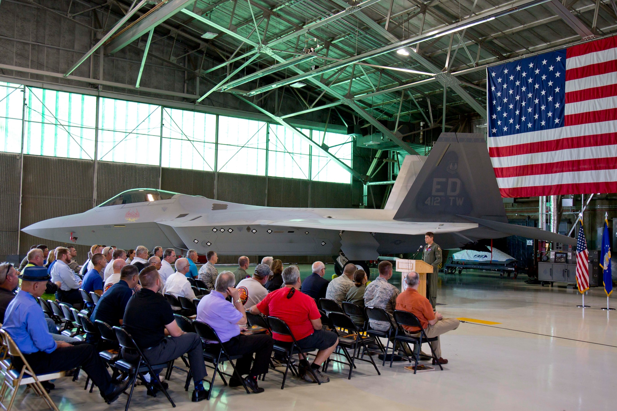 Lt. Col. Lee Bryant, 411th Flight Test Squadron commander and F-22 Combined Test Force director, addresses base leadership along with Lockheed Martin and Boeing representatives and guests, to welcome back to life Raptor # 91-4006, which has been on the ground for almost six years. (Courtesy photo by Christopher Higgins/Lockheed Martin)