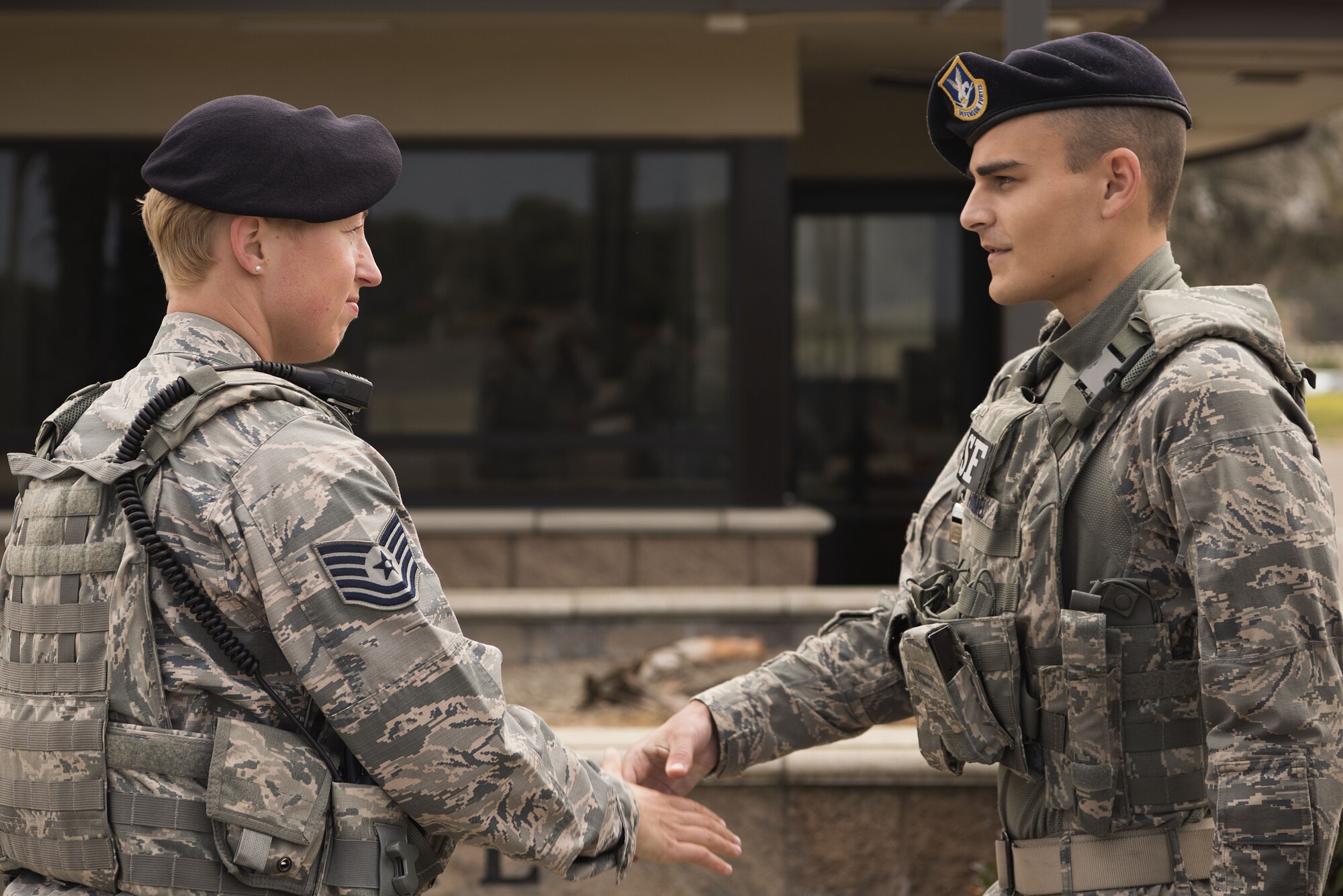 Tech. Sgt. April Spilde, flight chief for the 30th Security Forces Squadron, shakes hands with Airman 1st Class Marcus Hammel, Charlie flight member, during a post check August 2, 2018, on Vandenberg Air Force base. Spilde manages one flight of Airmen and makes sure they are able to perform their daily duties. (U.S. Air Force photo by Airman 1st Class Hanah Abercrombie)