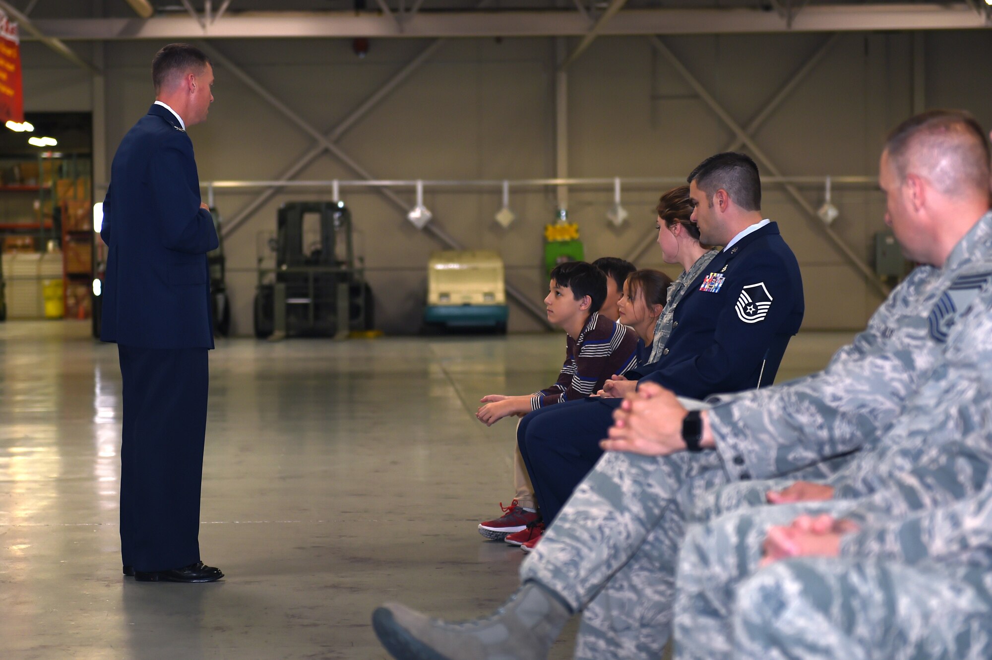 Col. Scovill W. Currin, 62nd Airlift Wing Commander, adresses the family of a Bronze Star award recipient Master Sgt. Derek J. Thompson, inside the 62nd Aerial Port Squadron August 28, 2018.