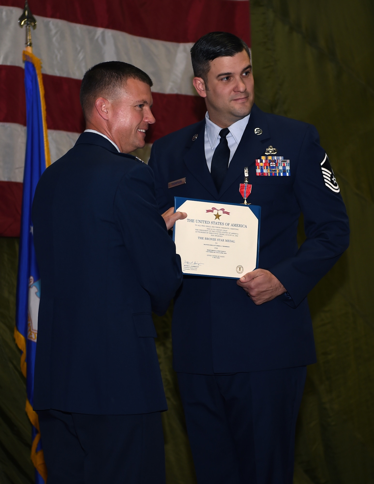 Col. Scovill W. Currin, 62nd Airlift Wing Commander, presents the Bronze Star award to Master Sgt. Derek J. Thompson, inside the 62nd Aerial Port Squadron August 28, 2018.