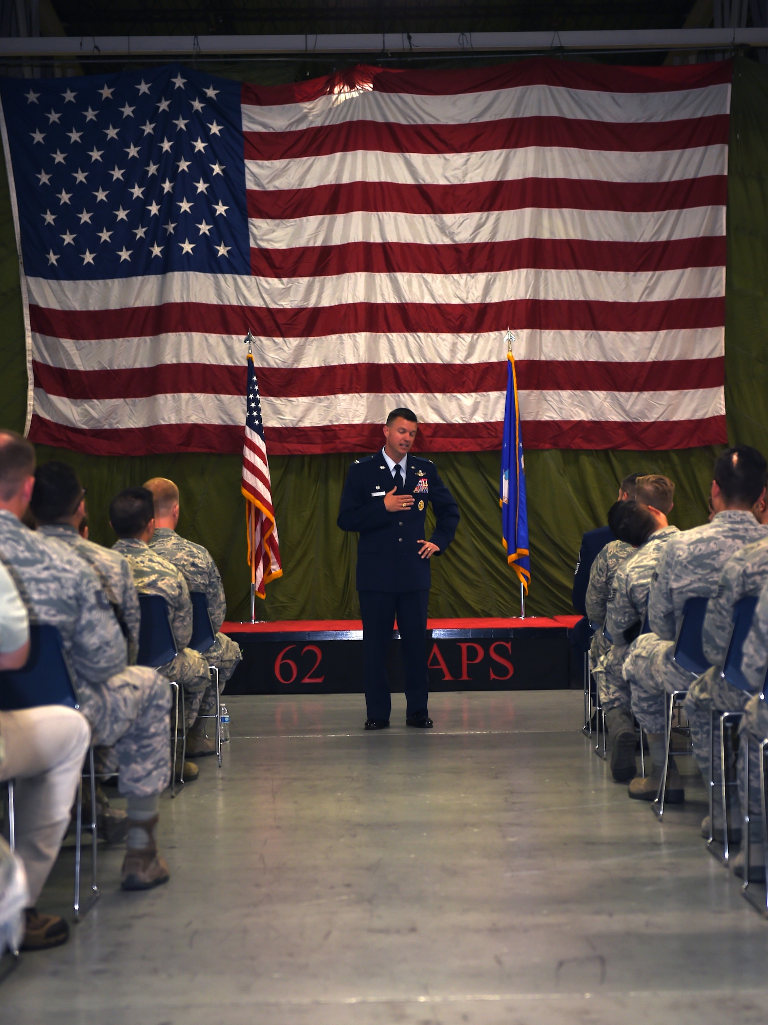 Col. Scovill W. Currin, 62nd Airlift Wing Commander, delivers a speech prior to presenting a Bronze Star award to Master Sgt. Derek J. Thompson inside the 62nd Aerial Port Squadron August 28, 2018.