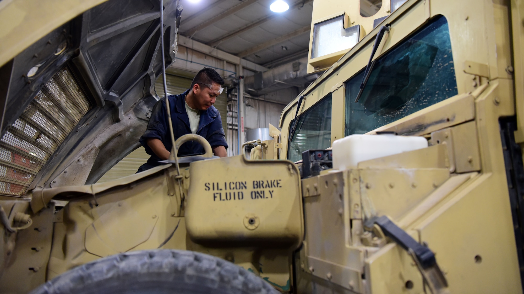 U.S. Air Force Staff Sgt. Denmark Castrence, 386th Expeditionary Logistics Readiness Squadron vehicle mechanic, inspects the engine bay of a Humvee Aug. 14, 2018, at an undisclosed location in Southwest Asia. Castrence and his team have been working with U.S. Army Fox Company 227 to maintain their occupational proficiency in addition to completing the mission. (U.S. Air Force photo by Staff Sgt. Christopher Stoltz)