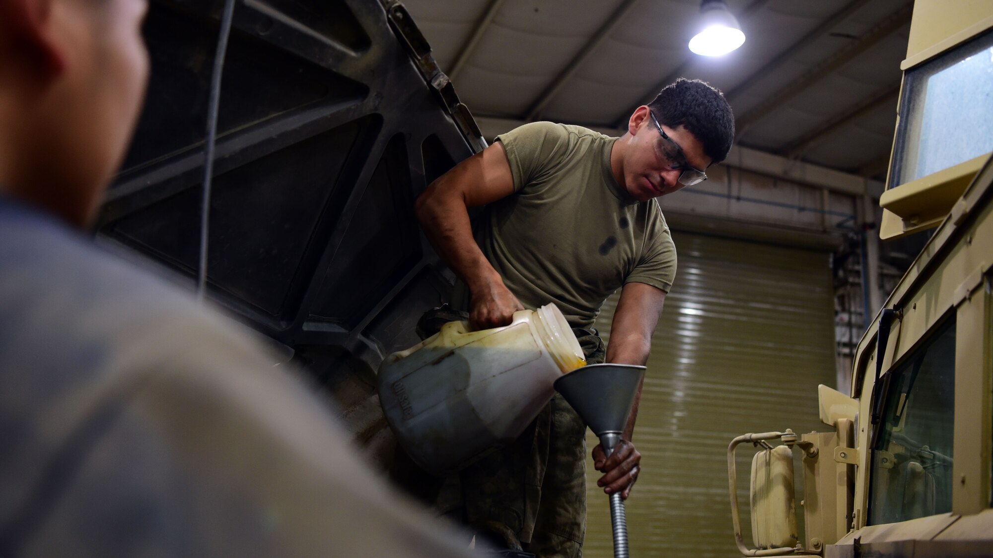 U.S. Army Private Christian Suarez, a wheeled-vehicle mechanic with Fox Company 227, 1st Attack Reconnaissance Battalion, 227th Aviation Regiment, 1st Air Cavalry Brigade, 1st Cavalry Division, replenishes the oil on a Humvee Aug. 14, 2018, at an undisclosed location in Southwest Asia. In addition to his responsibilities for the Army, Suarez has been augmenting the 386th Expeditionary Logistic Readiness Squadron. (U.S. Air Force photo by U.S. Air Force Staff Sgt. Christopher Stoltz)