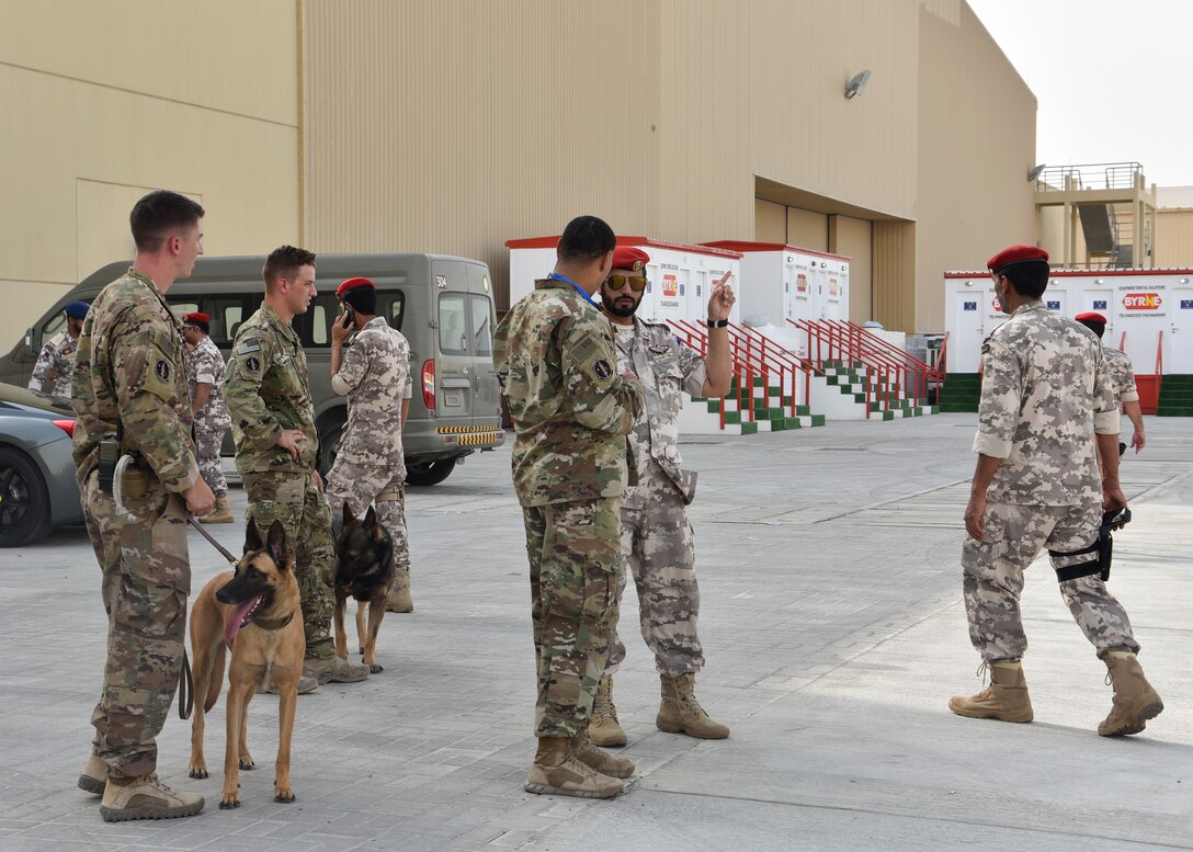 Members of the 379th Expeditionary Security Forces Squadron’s military working dog section partnered with host nation police to conduct security sweeps prior to the Air Force Central Command change of command ceremony at Al Udeid Air Base, Qatar, August 30, 2018. The joint efforts enabled a swift and efficient security process for the ceremony. (U.S. Air Force photo by Staff Sgt. Enjoli Saunders)
