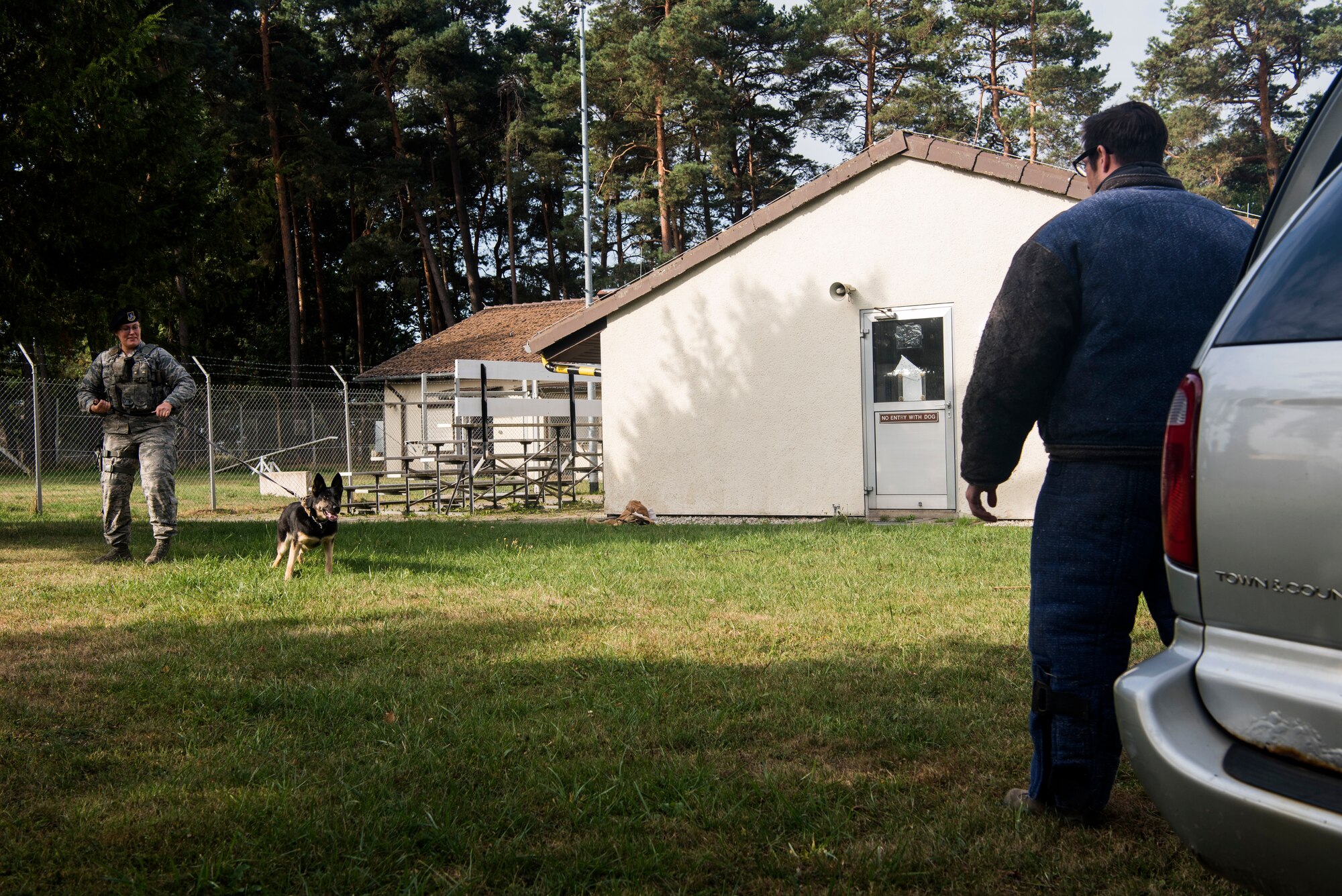 U.S. Air Force Staff Sgt. Adrienne Neuburger, 52nd Security Forces Squadron military working dog handler, left, and Staff Sgt. Michael Hensley, 52nd SFS MWD trainer, right, conduct vehicle extraction training at Spangdahlem Air Base, Germany, Aug. 28, 2018. Tina, a MWD, was taught the initial phase of how to remove a resistant suspect from a vehicle. (U.S. Air Force photo by Airman 1st Class Valerie Seelye)