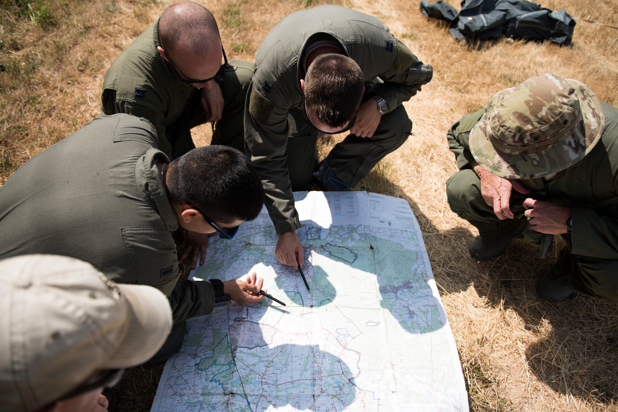 Aircrew from the 48th Operations Group review a map prior to their Combat Survival Training at the Stanford Training Area in Norfolk, England, July 25, 2018. Pilots and other aircrew are required to receive refresher training on these skills every three years. (U.S. Air Force photo/Senior Airman Malcolm Mayfield)