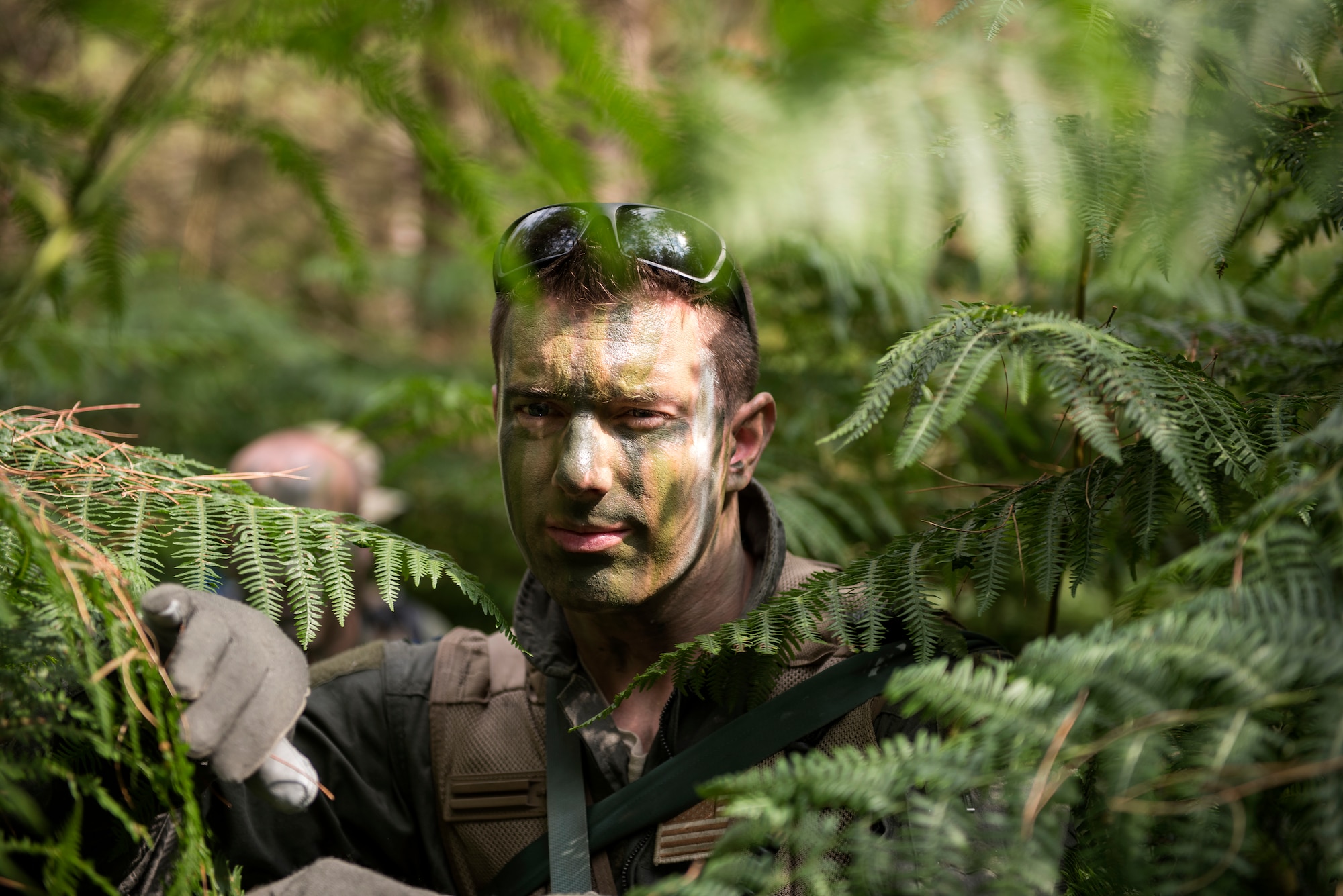 An Airman from the 48th Operations Group carefully maneuvers through vegetation to avoid detection during Combat Survival Training at the Stanford Training Area in Norfolk, England, July 25, 2018. A combined effort of the 48th Fighter Wing, 100th Refueling Wing and 352nd Special Operations Group SERE teams ensure that USAFE aircrews receive the best training possible in the U.K., and provide Airmen with a plethora of resources to draw knowledge from. (U.S. Air Force photo/Senior Airman Malcolm Mayfield)