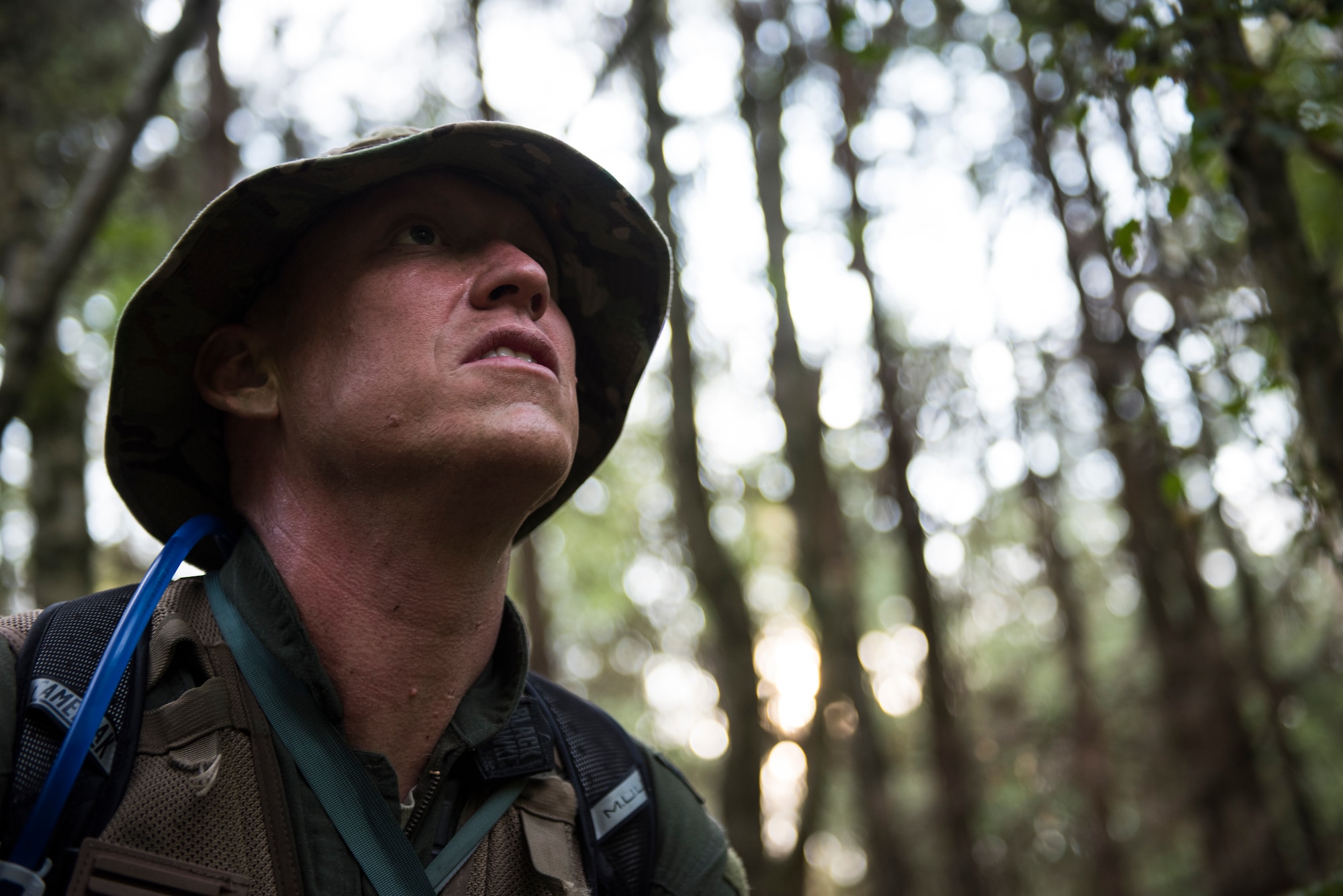 An Airman from the 48th Operations Group scans his surrounds to avoid detection during Combat Survival Training at the Stanford Training Area in Norfolk, England, July 25, 2018. Pilots and other aircrew are required to receive refresher training on these skills every three years. (U.S. Air Force photo/Senior Airman Malcolm Mayfield)