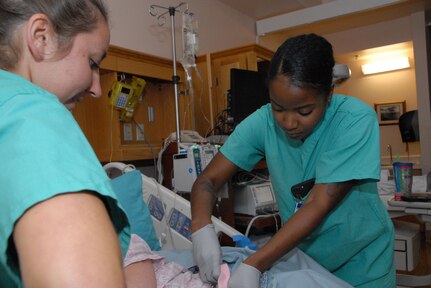 Oregon Air National Guard Staff Sgt. Anina Anderson, right, assists U.S. Army 1st Lt. Elizabeth Lane with preparing a patient for delivery in the Labor & Delivery section at Tripler Army Medical Center, in Honolulu, Hawaii, Aug. 28, 2018. Anderson and her fellow Airmen from the 142nd Medical Group took part in Medical Facilities Annual Training Aug. 18-31, 2018, and were able to assist in a real-world support mission when Hurricane Lane threatened to strike the Hawaiian Islands the week of Aug. 20, 2018.