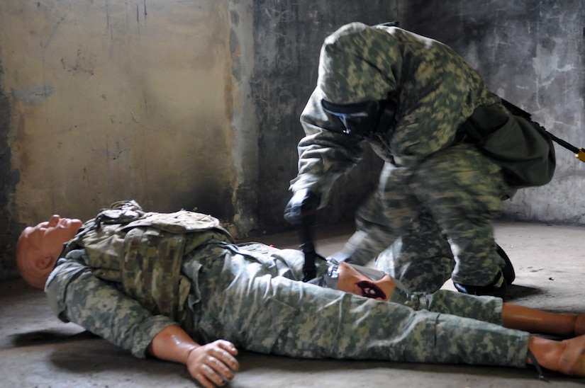 Army Capt. Stona Jackson, assigned to Regional Health Command Europe, assesses a simulated casualty during a chemical, biological, radiological, nuclear event during the 21st Theater Sustainment Command’s annual Best Medic Competition in Baumholder, Germany.