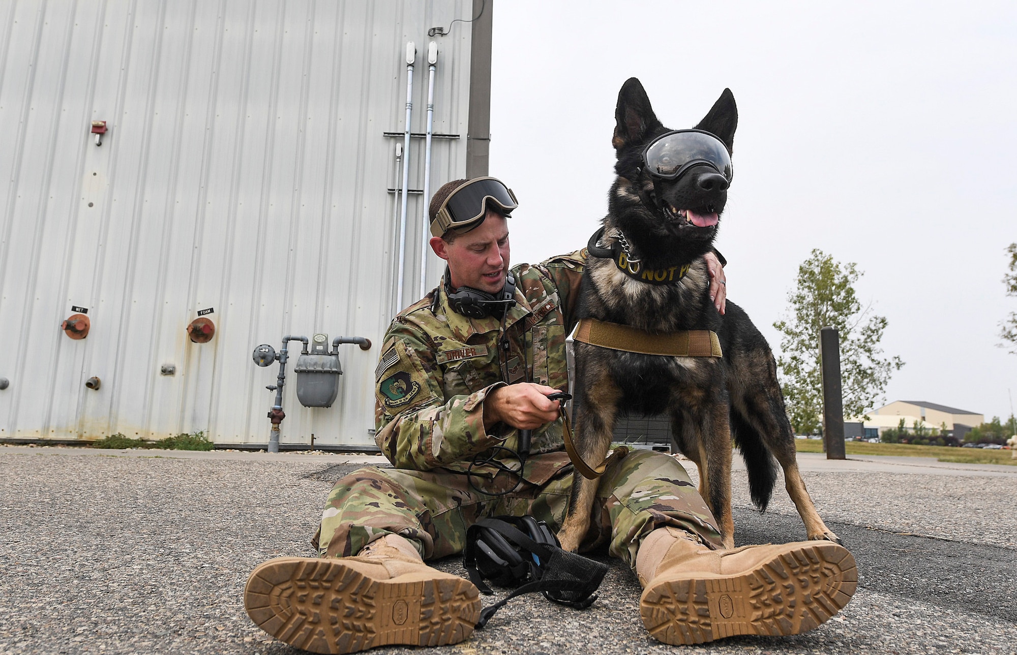 Staff Sgt. Timothy Driver, 5th Security Forces Squadron military working dog handler, adjusts safety equipment for Deny, 5th SFS MWD, during flight familiarization training at Minot Air Force Base, N.D., Aug. 23, 2018. This was the first time the K-9 unit has flown with the 54th Helicopter Squadron. (U.S. Air Force photo by Senior Airman Jonathan McElderry)