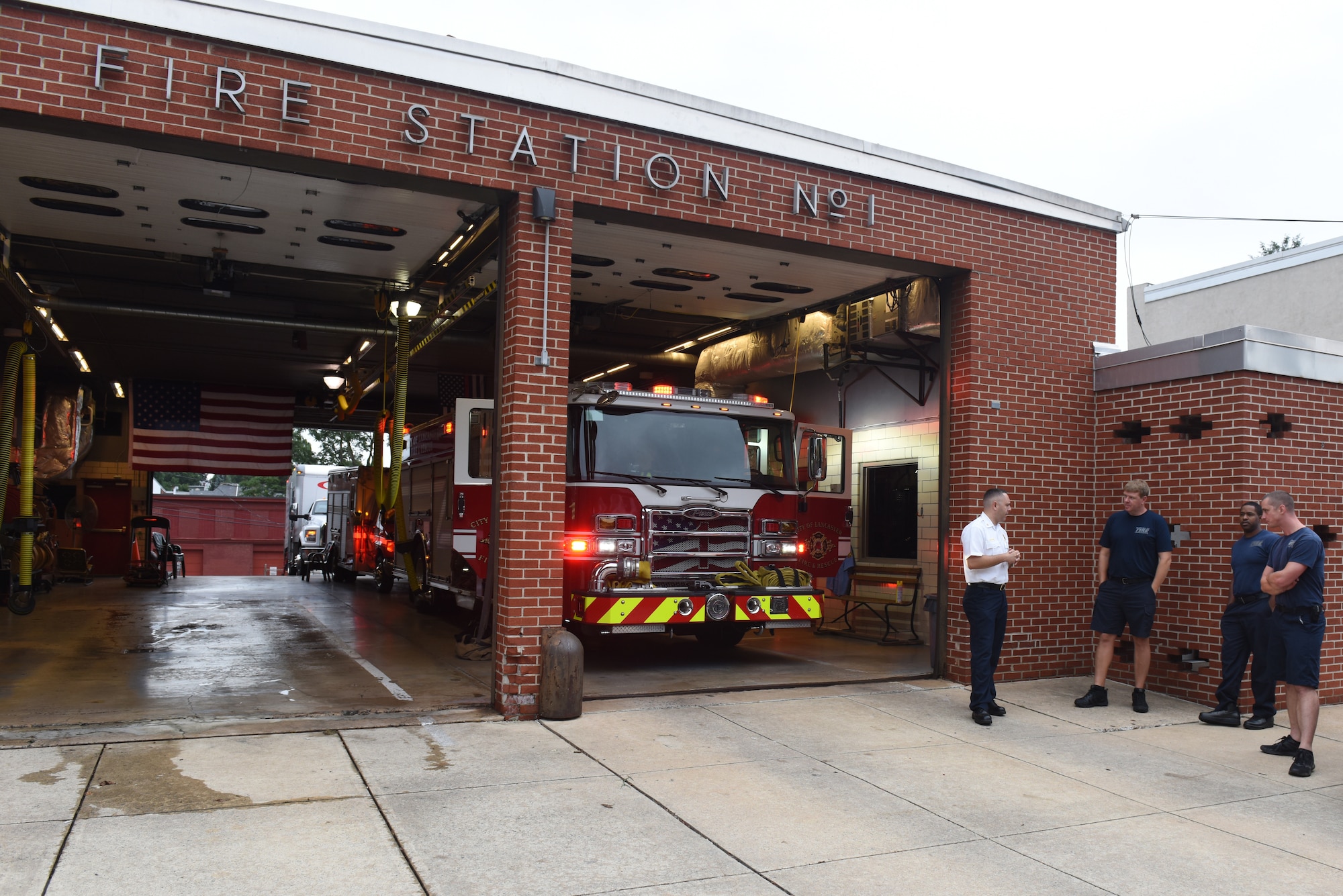 Scott Little, left, fire chief of Lancaster’s Bureau of Fire, talks with firefighters outside of station number one regarding maintenance being done to their firetruck Aug. 21, 2018, Lancaster, Pennsylvania. Little is the first fire chief hired from outside of the organization since Lancaster’s Bureau of Fire was organized as a career fire department in 1882. (U.S. Air National Guard photo by Senior Airman Julia Sorber/Released)