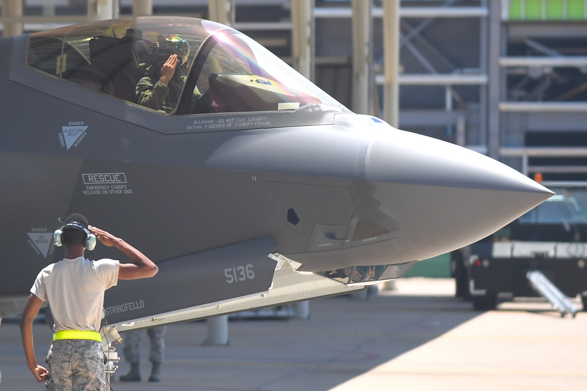 Airman Jarret Smith, 388th Aircraft Maintenance Squadron, and a pilot from the 4th Fighter Squadron, exchange salutes before a training sortie, Aug. 8, 2018, Hill Air Force Base, Utah. Airmen and F-35s from the active-duty 388th Fighter Wing and Reserve 419th Fighter Wing at Hill AFB participated in the Air Force’s Weapon System Evaluation Program known as Combat Hammer. (U.S. Air Force photo by Todd Cromar)