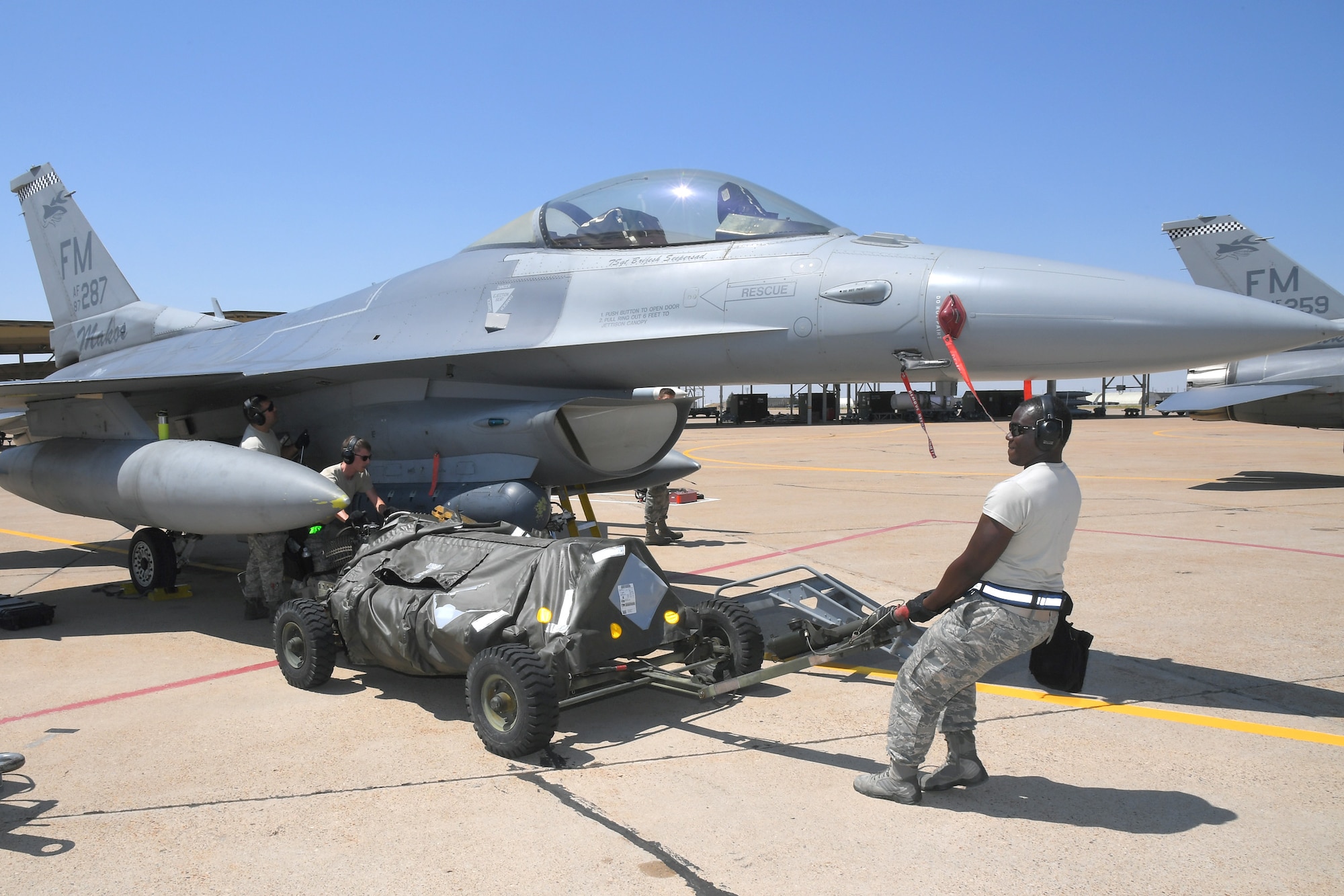 (Left to right) Senior Airman Jeremy Watson and Tech. Sgt. Darian Willis, 482nd Aircraft Maintenance Squadron, reposition an ammo cart for loading target rounds on an F-16, Aug. 8, 2018, at Hill Air Force Base, Utah. The 482nd AMXS from Homestead Air Reserve Base, Fla., was at Hill AFB to participate in the Air Force’s Weapon System Evaluation Program known as Combat Hammer. (U.S. Air Force photo by Todd Cromar)