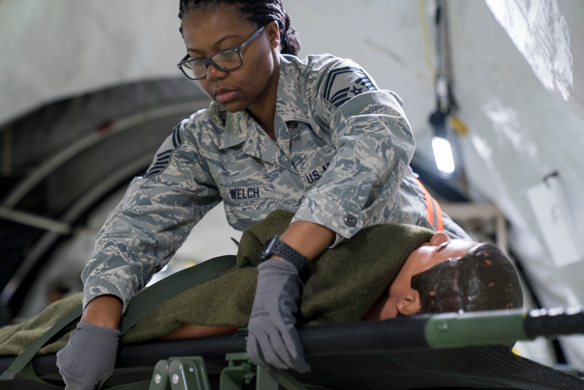 U.S. Air Force Reserve Senior Master Sgt. Nolisa Welch, 413th Aeromedical Staging Squadron superintendent of nursing services, secures a simulated patient during Exercise Ultimate Caduceus 2018 at Travis Air Force Base, California, Aug. 22, 2018. Ultimate Caduceus 2018 is an annual patient movement exercise designed to test the ability of U.S. Transportation Command to provide medical evacuation. (U.S. Air Force photo by Jamal D. Sutter)