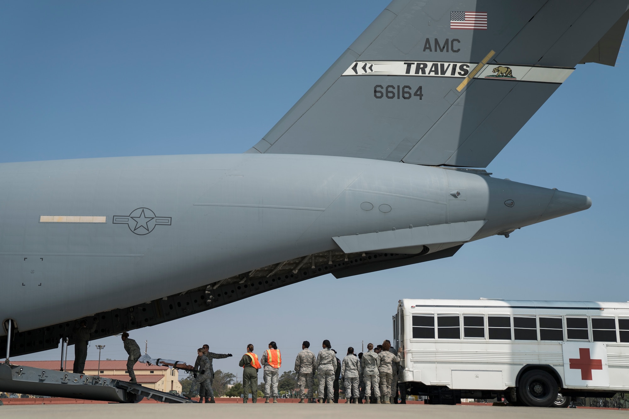 U.S. Air Force medical personnel load simulated patients from an ambulance bus onto a C-17 Globemaster III during Exercise Ultimate Caduceus 2018 at Travis Air Force Base, California, Aug. 23, 2018. Ultimate Caduceus 2018 is an annual patient movement exercise designed to test the ability of U.S. Transportation Command to provide medical evacuation. (U.S. Air Force photo by Jamal D. Sutter)