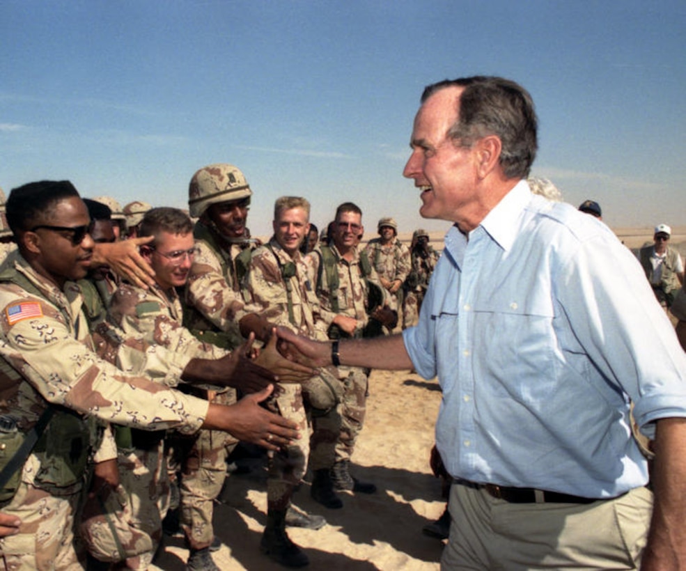 President George H.W. Bush shakes hands with U.S. troops.